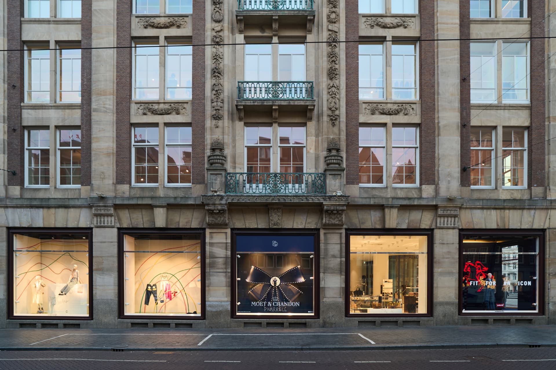 Bijenkorf facade with the Moët & Chandon window at dusk