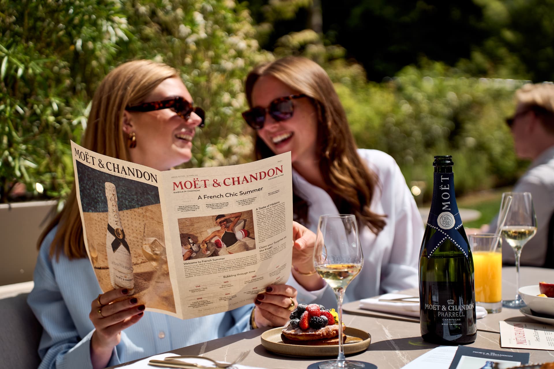 Two guests reading the summer paper in the garden