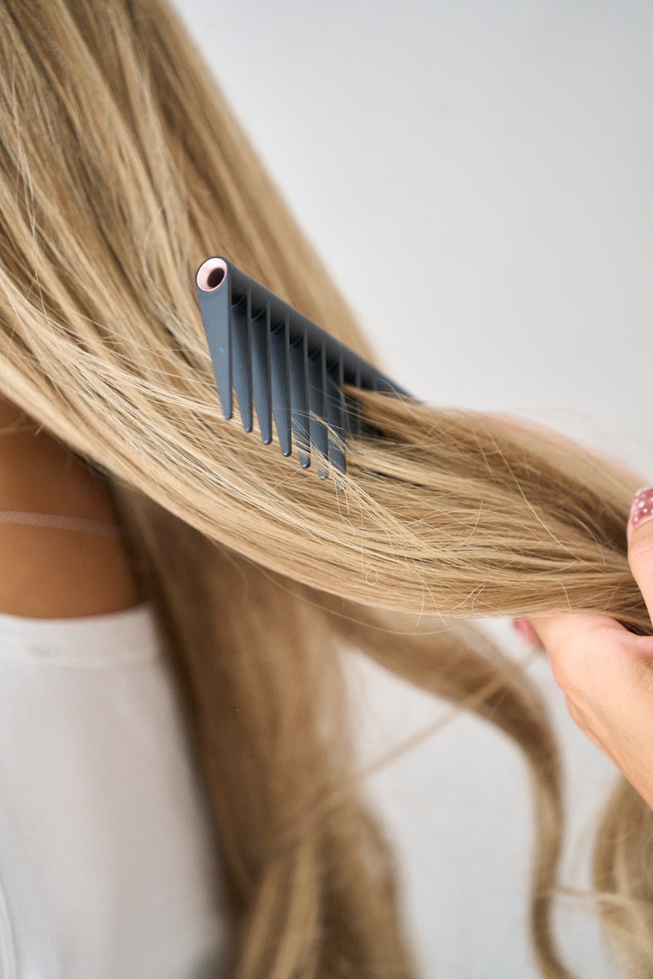 Wide tooth comb drawn through long blonde hair