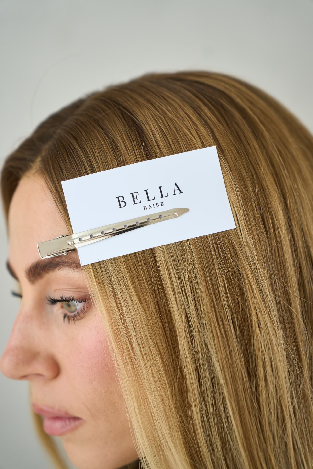 Bella Haire card clipped into a blonde hairline