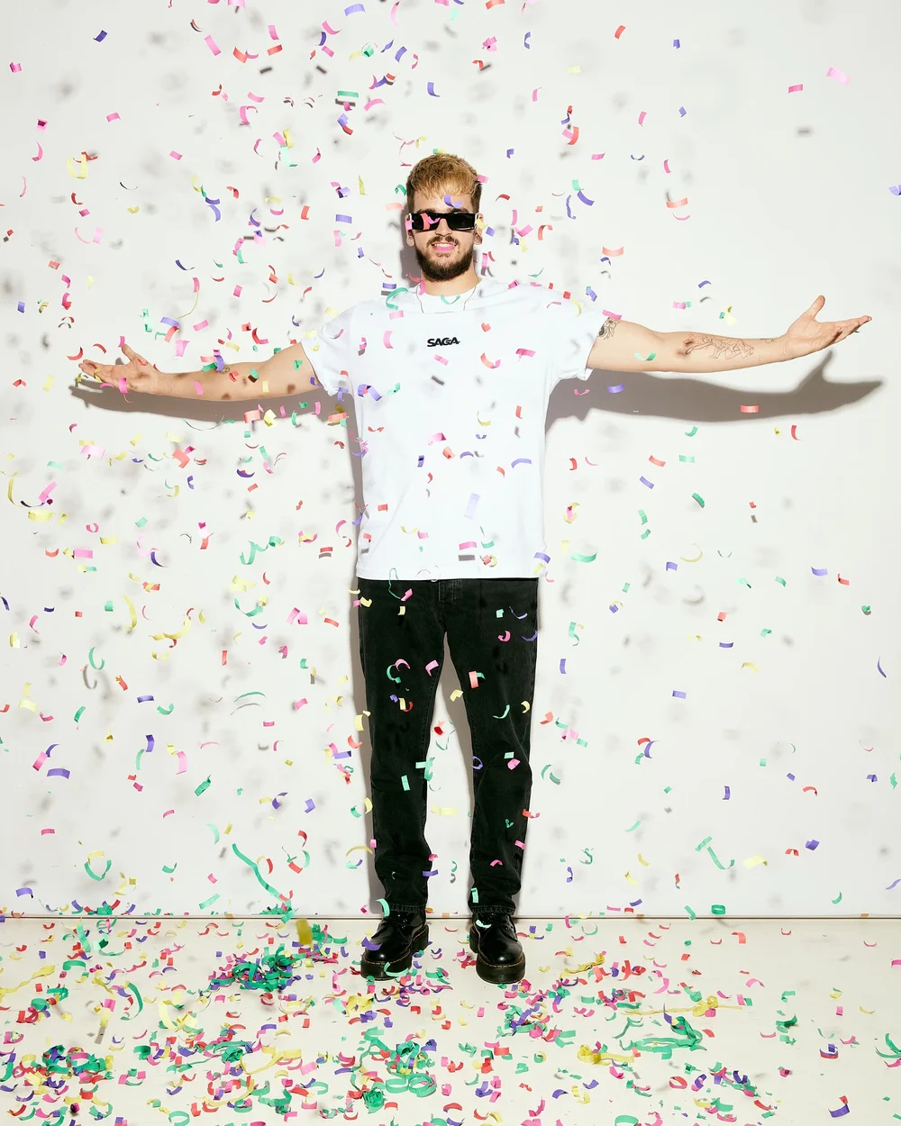 Model in a white SAGA tee under falling confetti