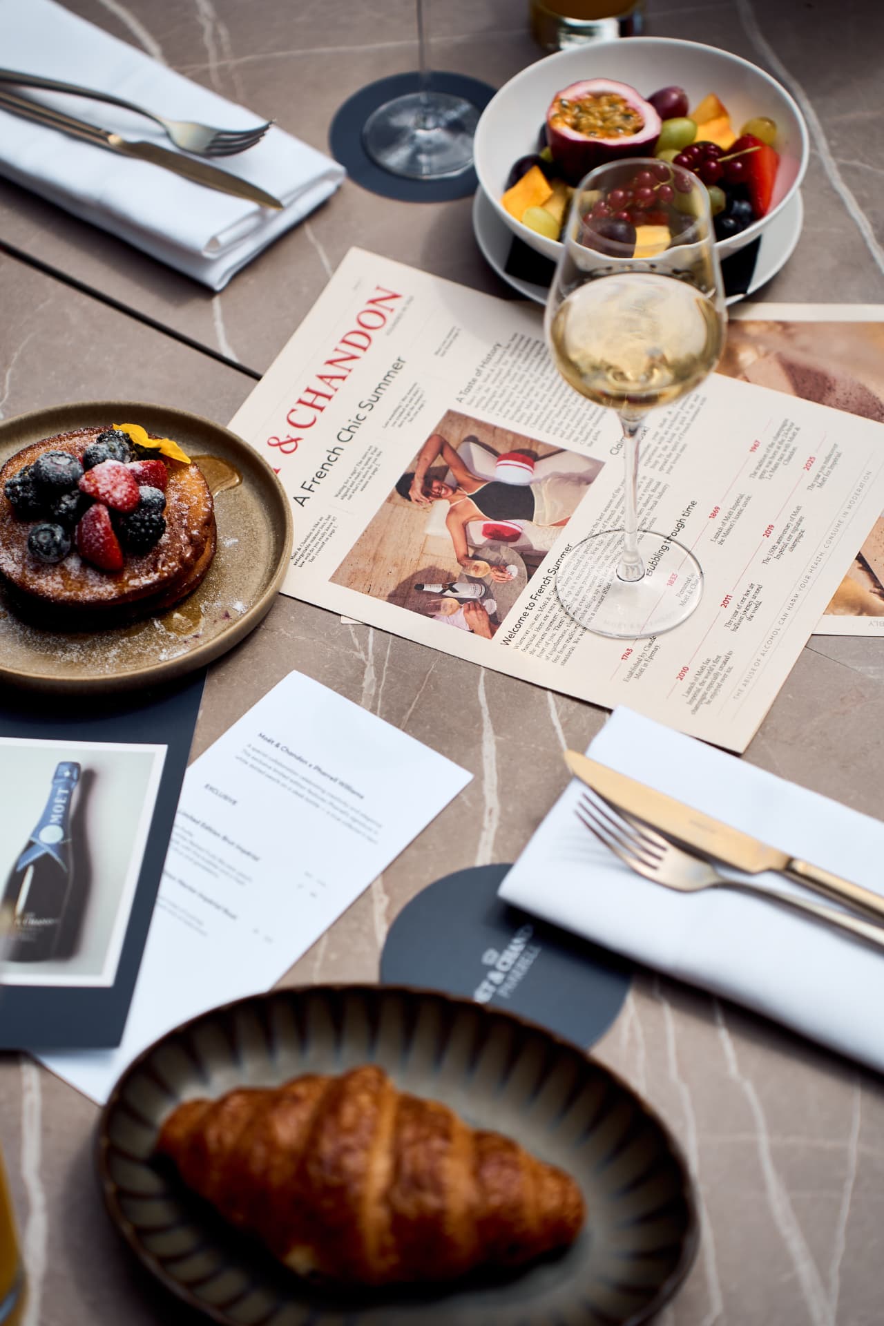Table set with pancakes, fruit and the summer paper