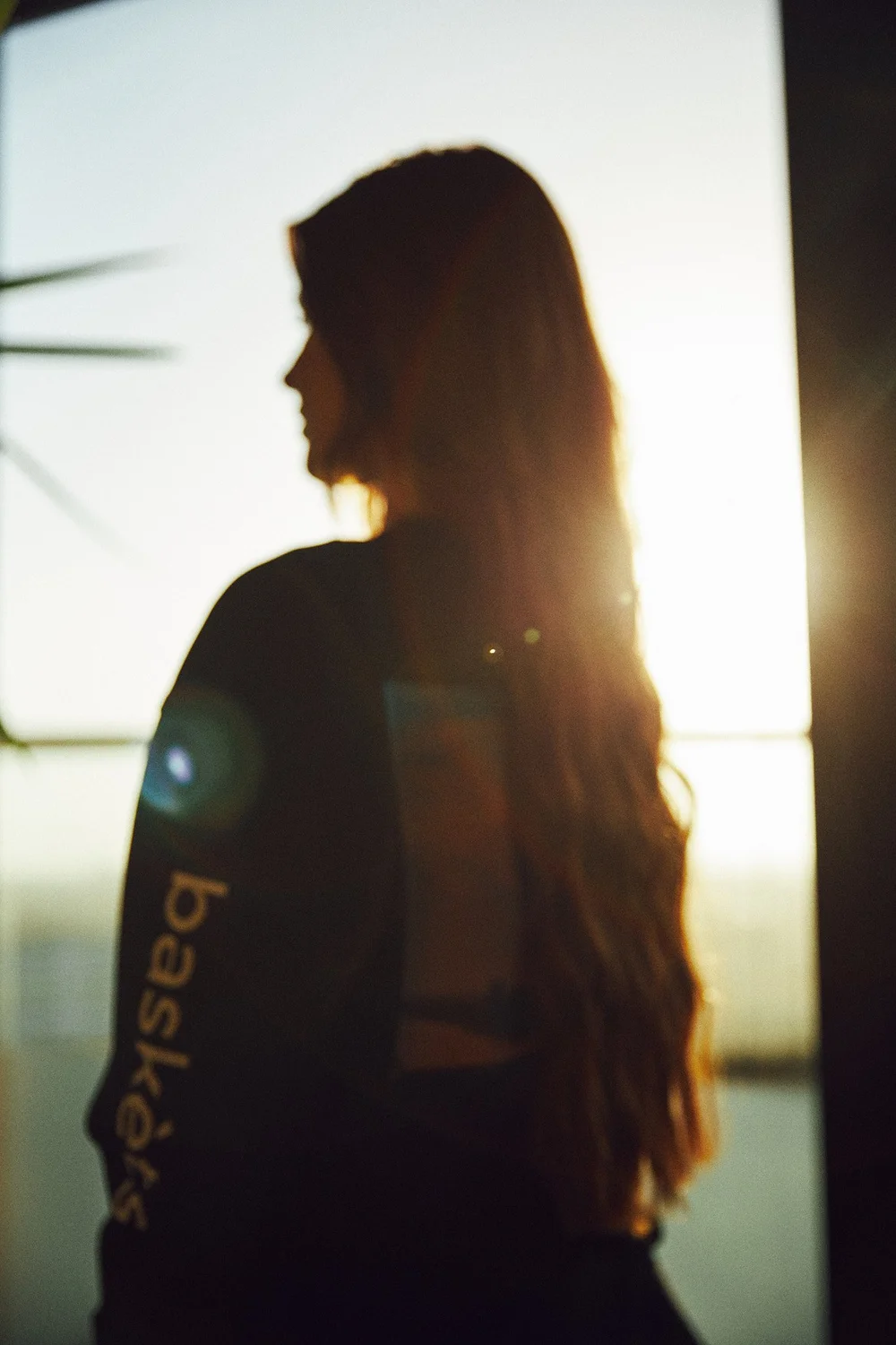 Backlit silhouette of a model in a BASKÈTS long sleeve