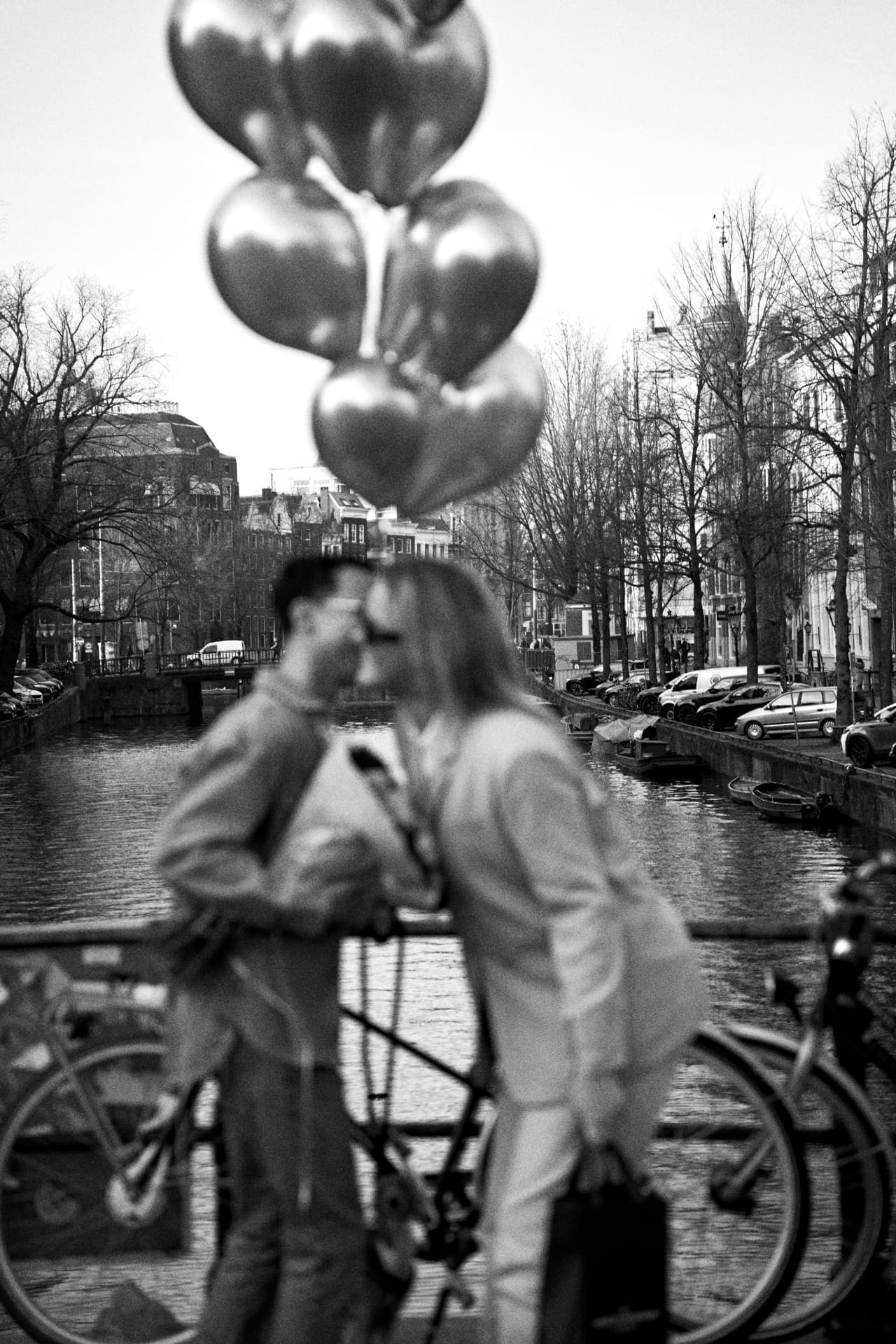 Couple on a bridge behind silver balloons