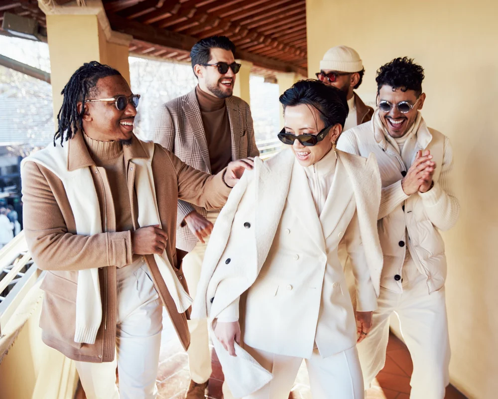 Group in cream and camel tailoring walking a loggia in Florence