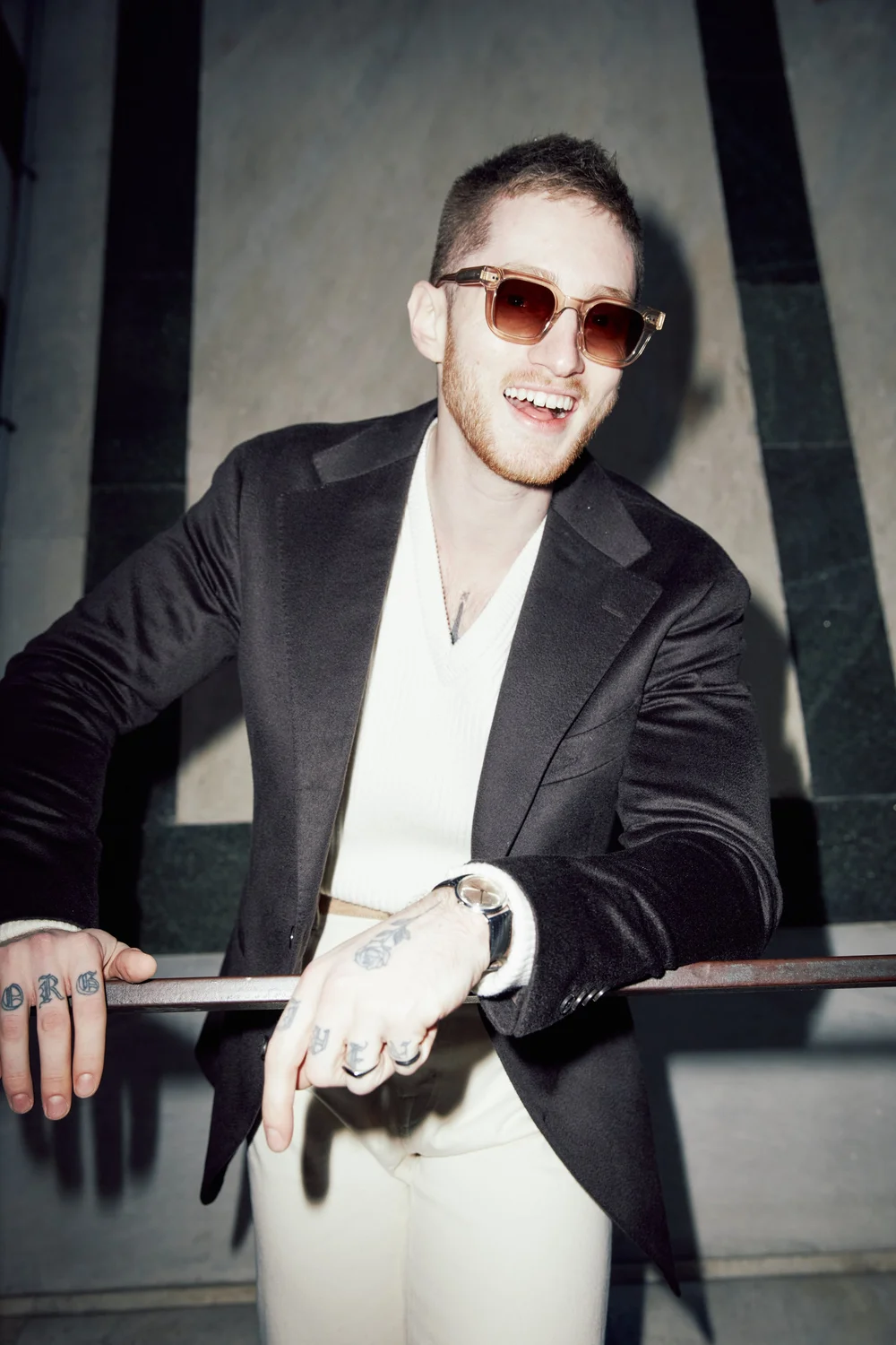 Portrait in a black jacket and cream knit on stone steps