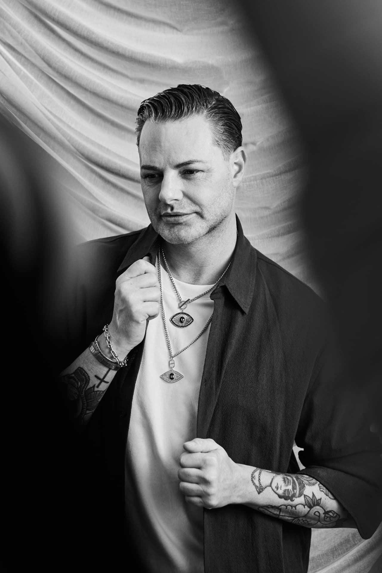 Black and white portrait of Fred van Leer against draped linen
