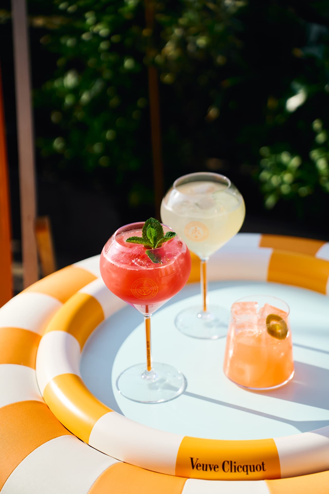 Cocktails in branded glasses inside a striped float