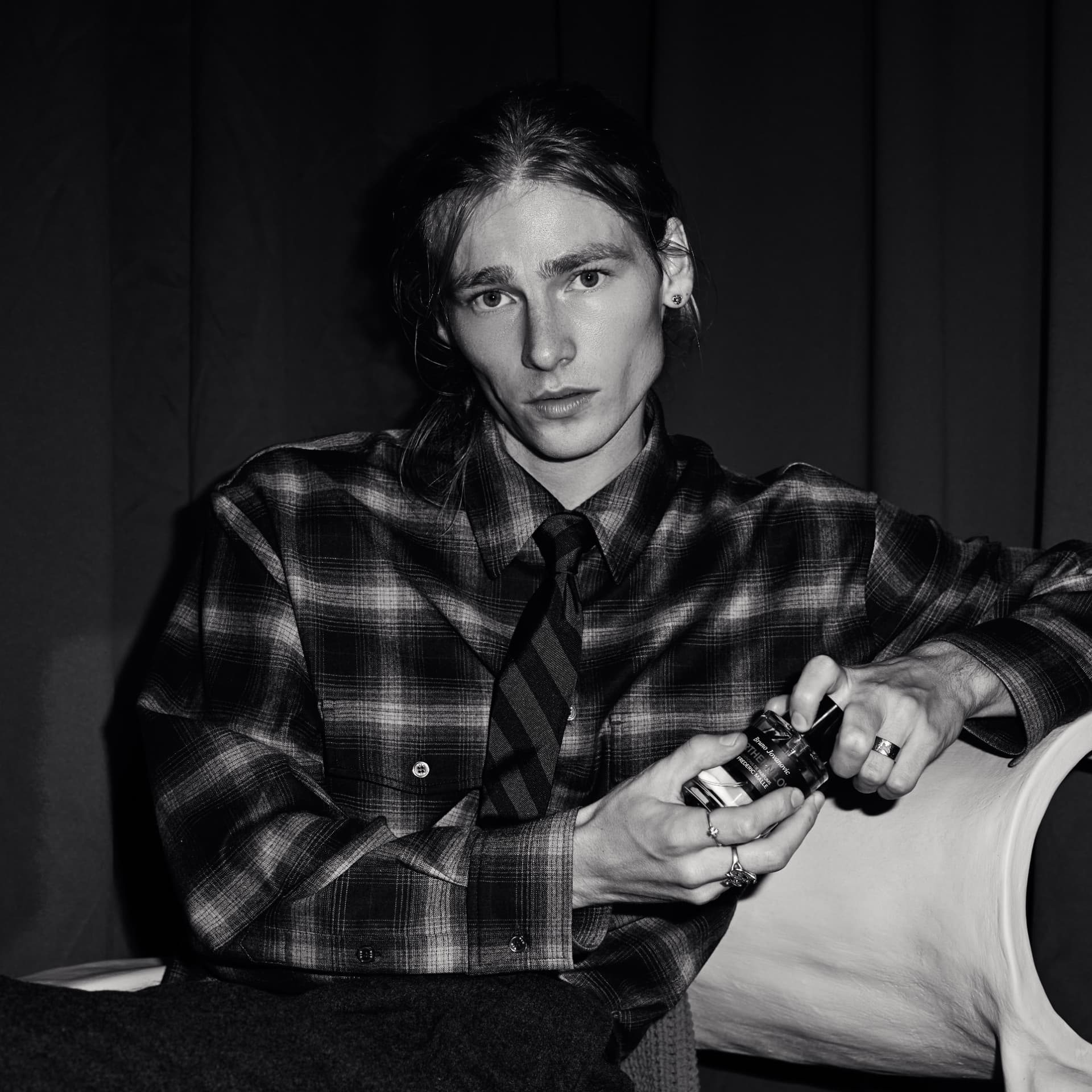 Black and white portrait of a guest in a checked shirt holding the bottle