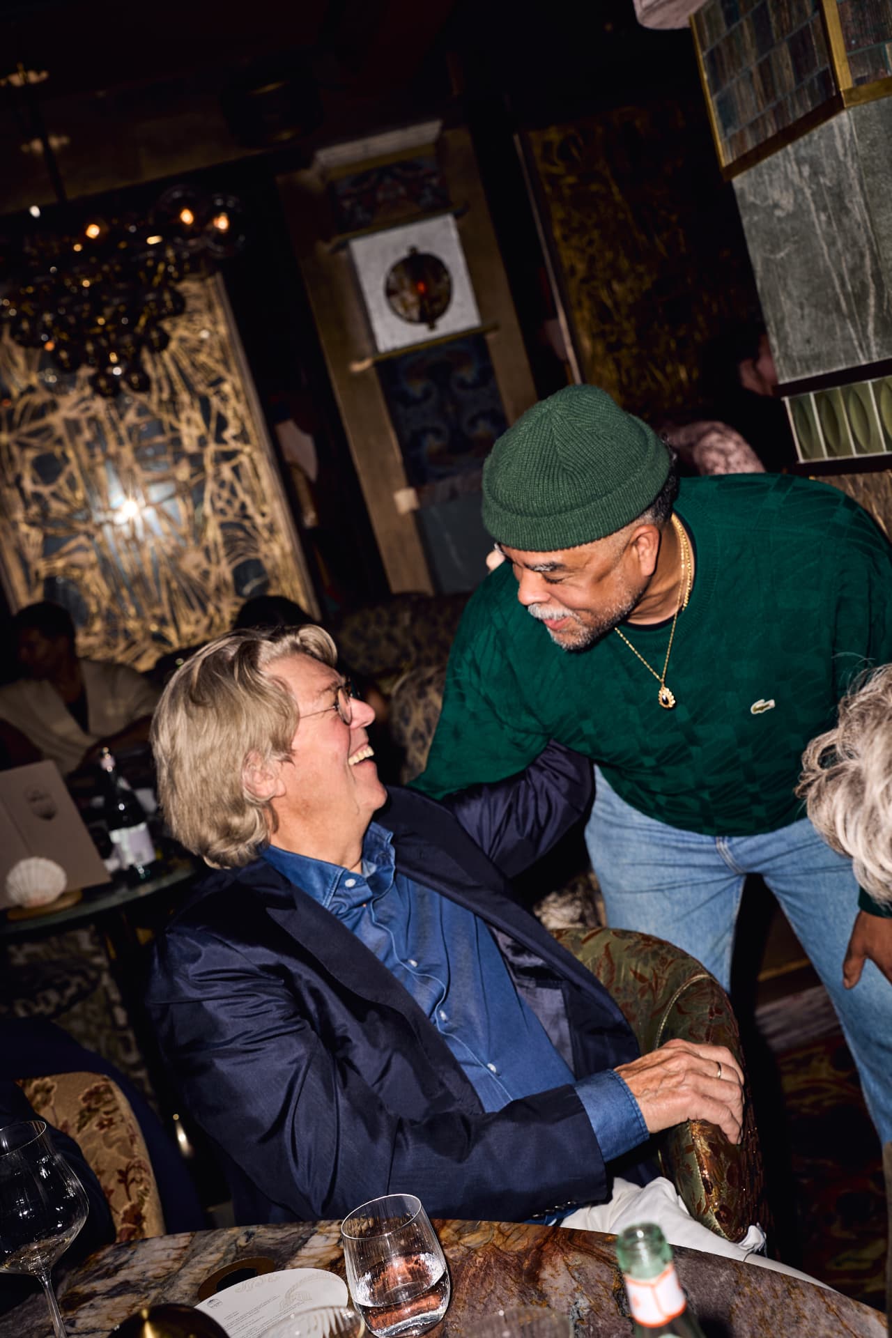 Two guests greeting each other in a booth