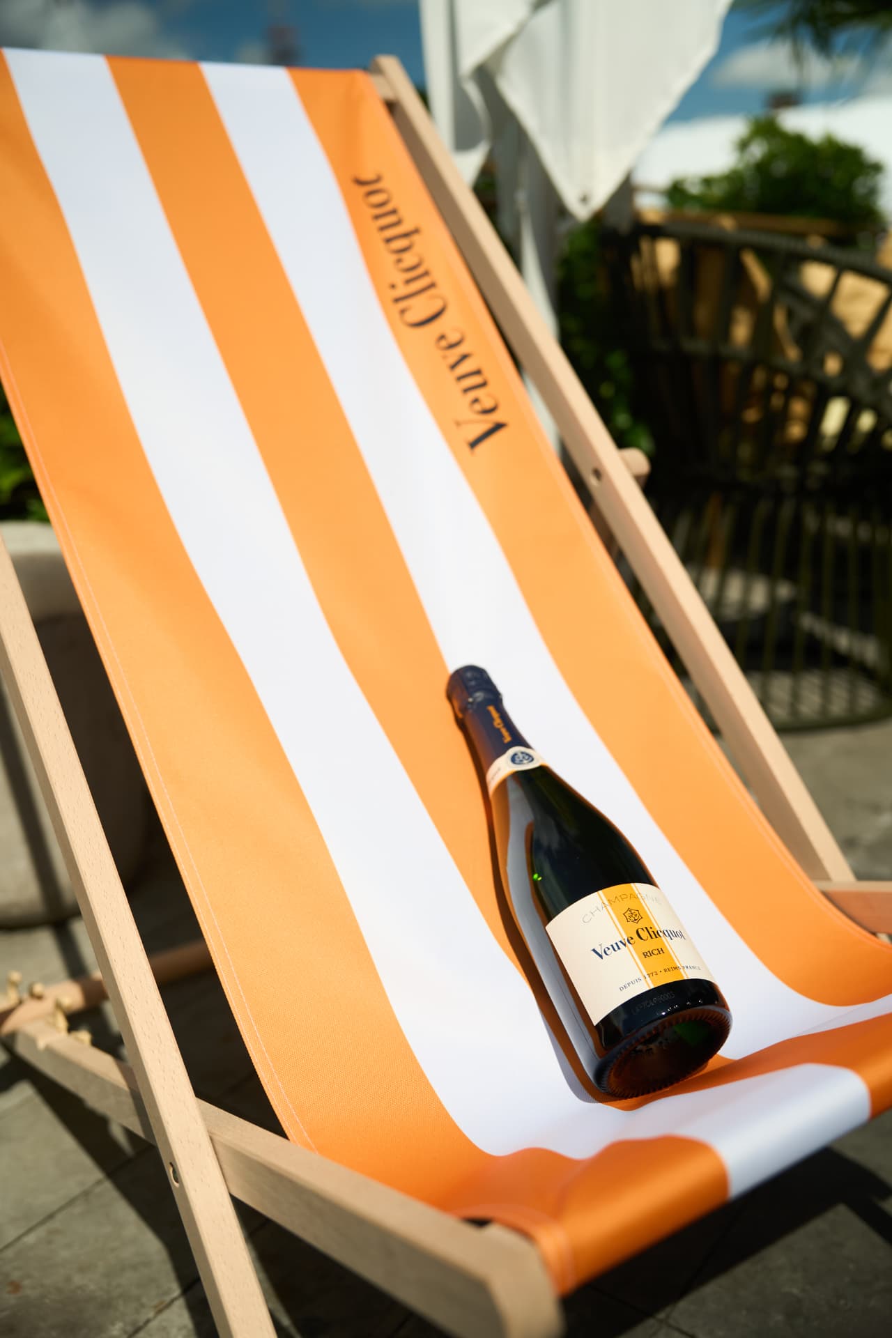 Bottle resting on a striped deck chair