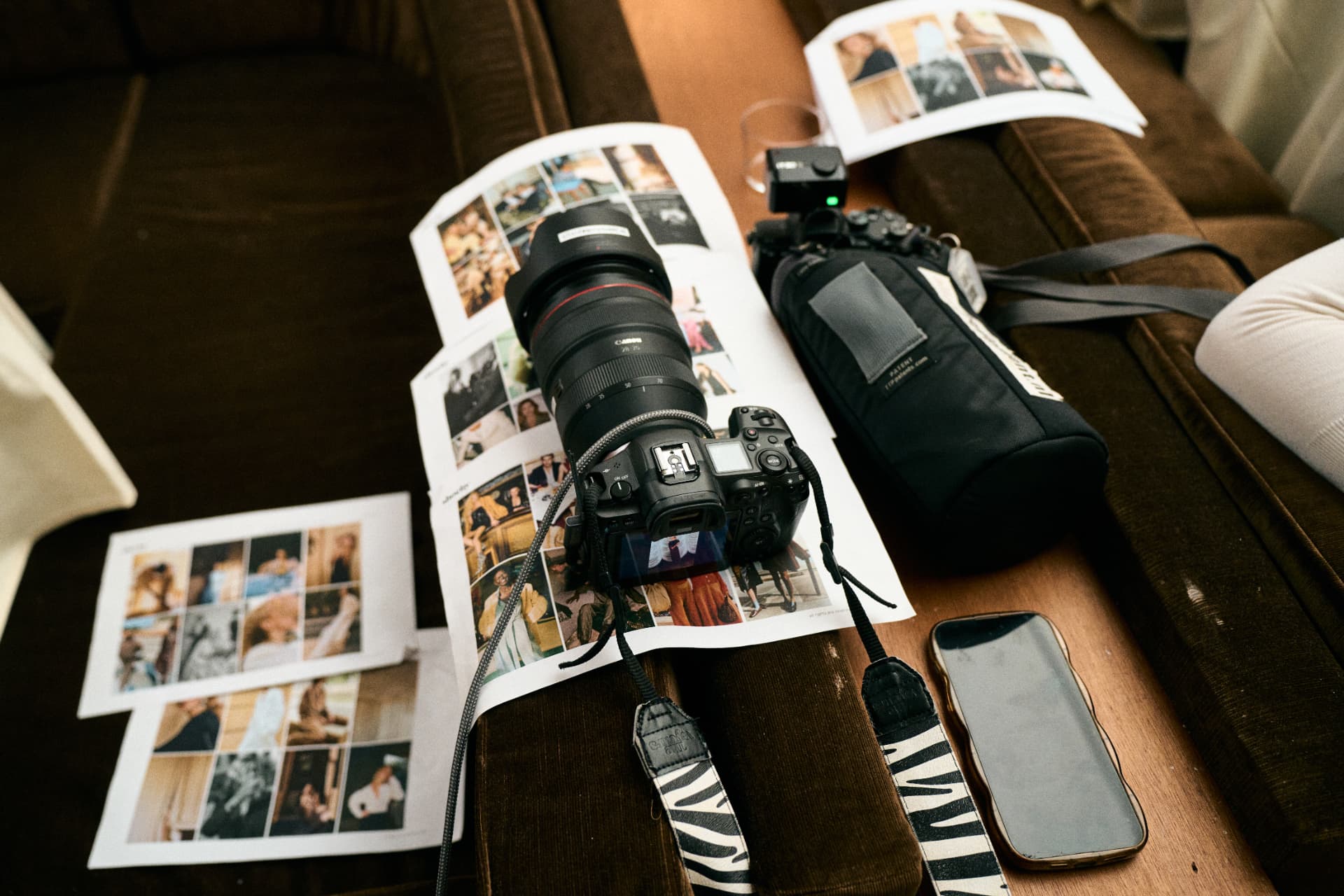 Camera and printed contact sheets on a velvet sofa