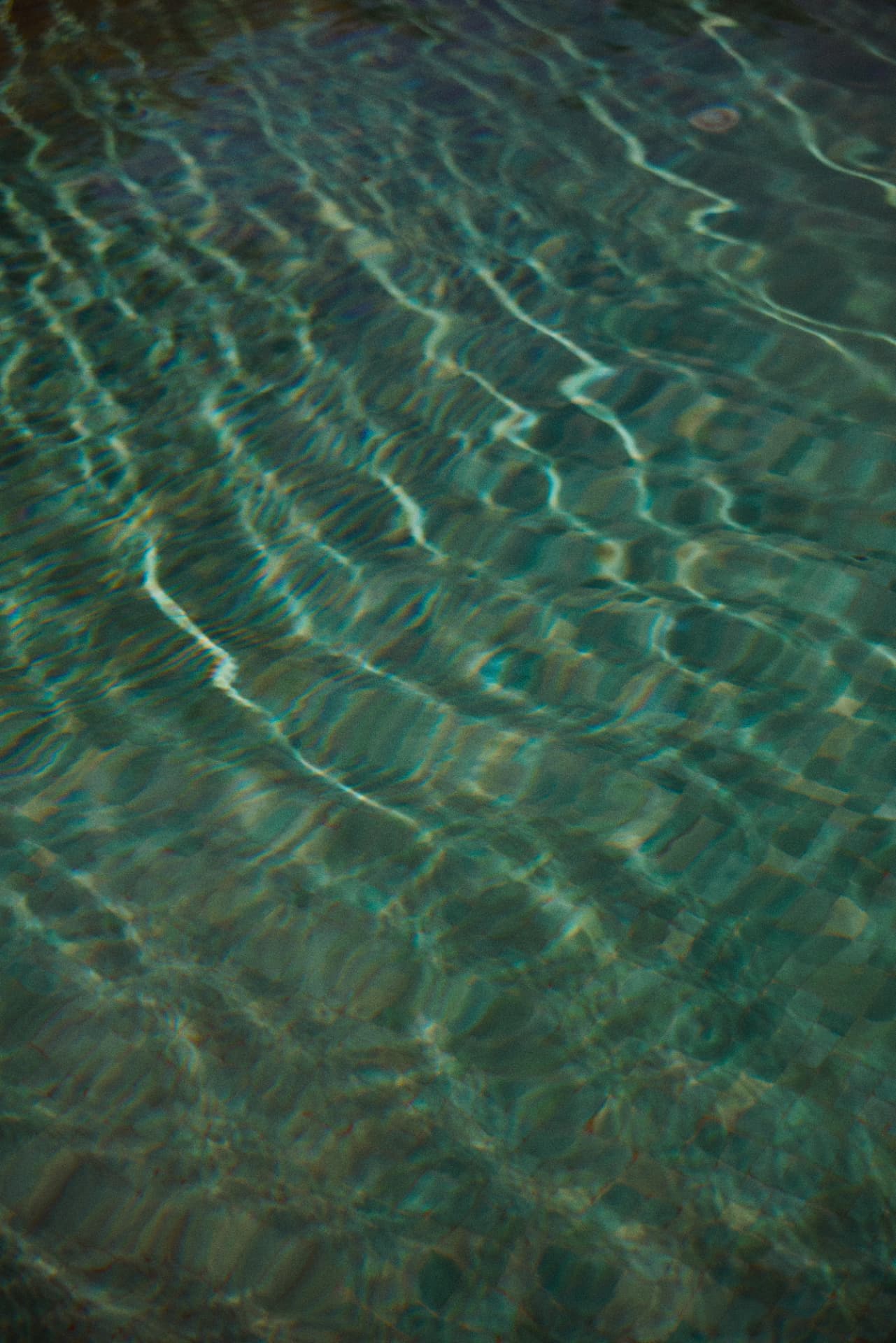 Sunlight rippling across the turquoise pool water