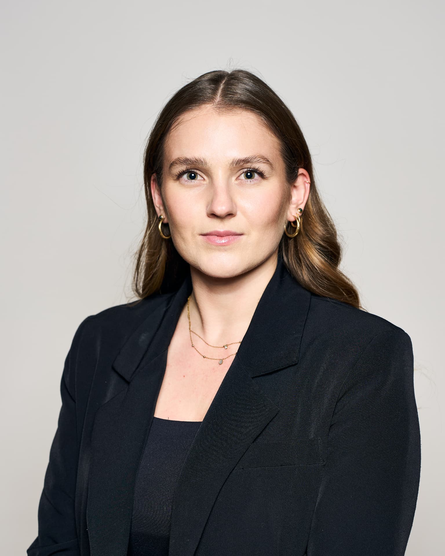 Zakelijk portret van een jonge vrouw in zwarte blazer