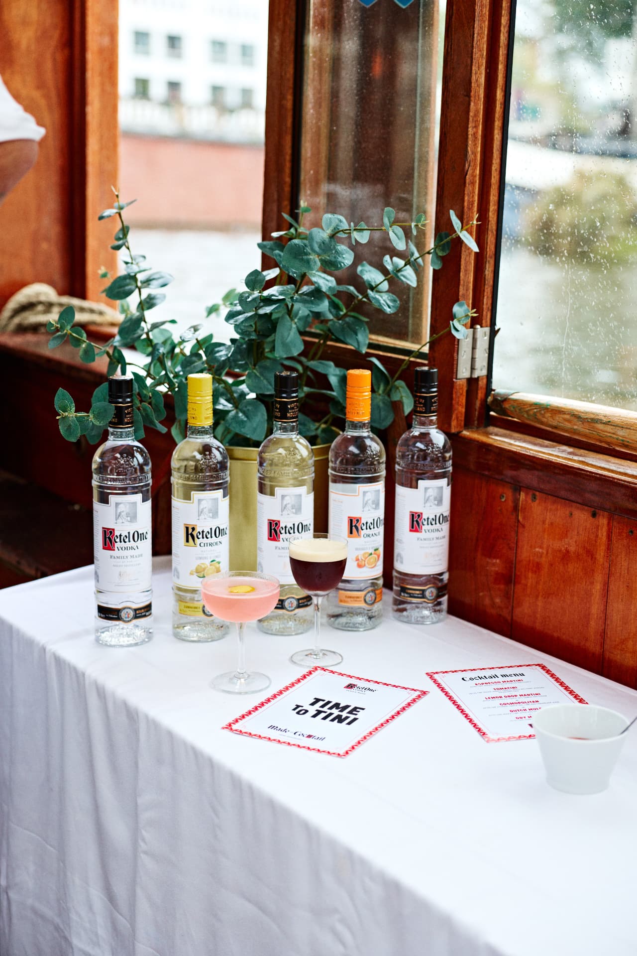 Ketel One bottles and citrus arranged beside a boat window