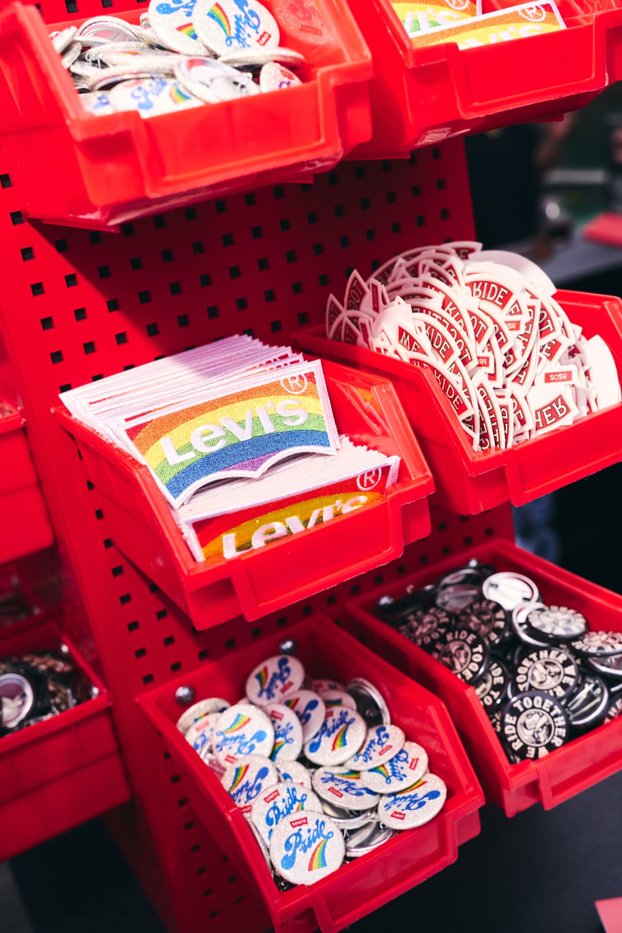 Red bins filled with Levi's Pride pins, patches and stickers