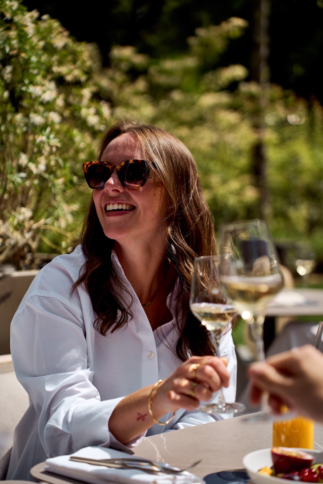 Guest laughing in a white shirt in the garden