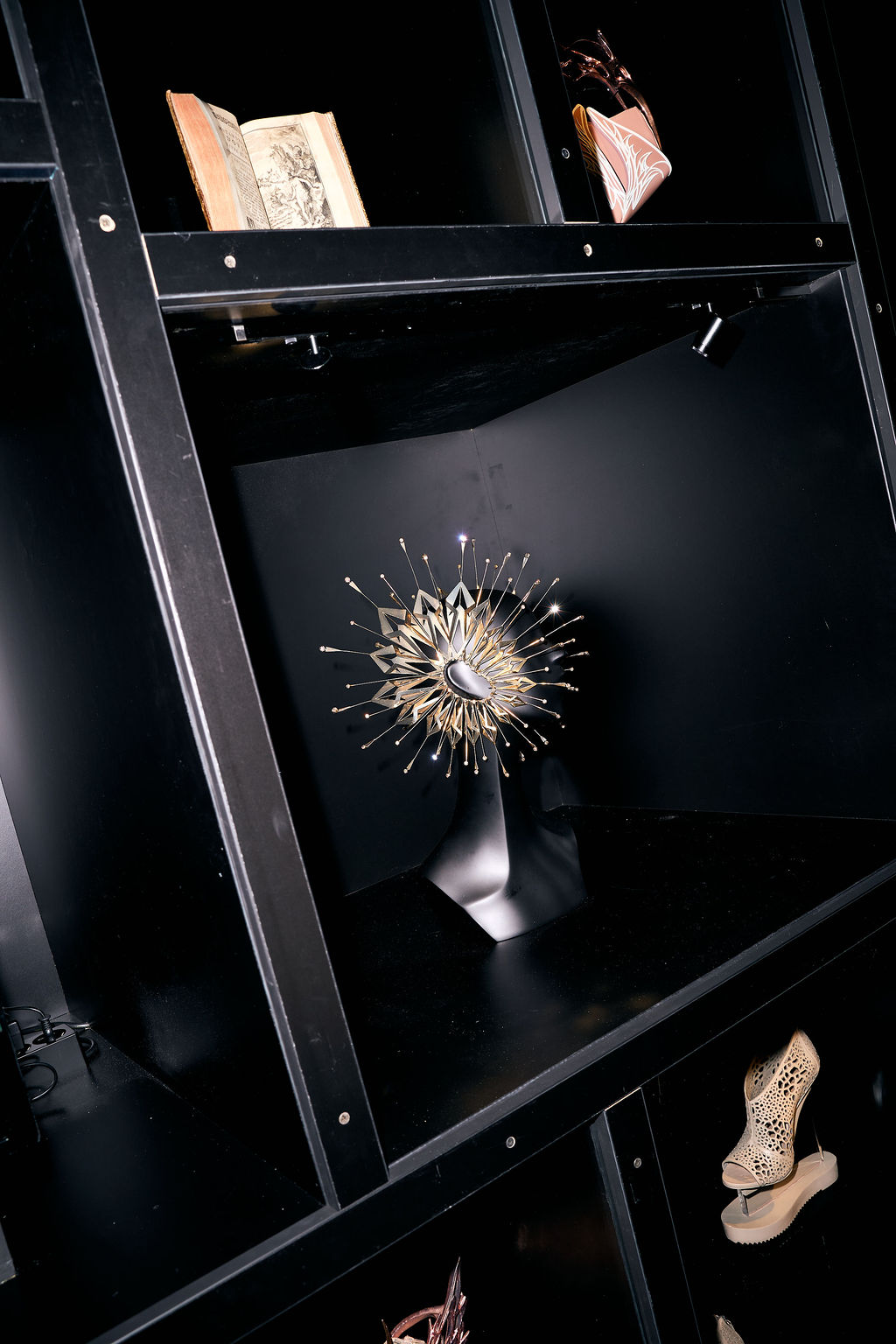 Lit vitrine with a jewelled headpiece and a printed book