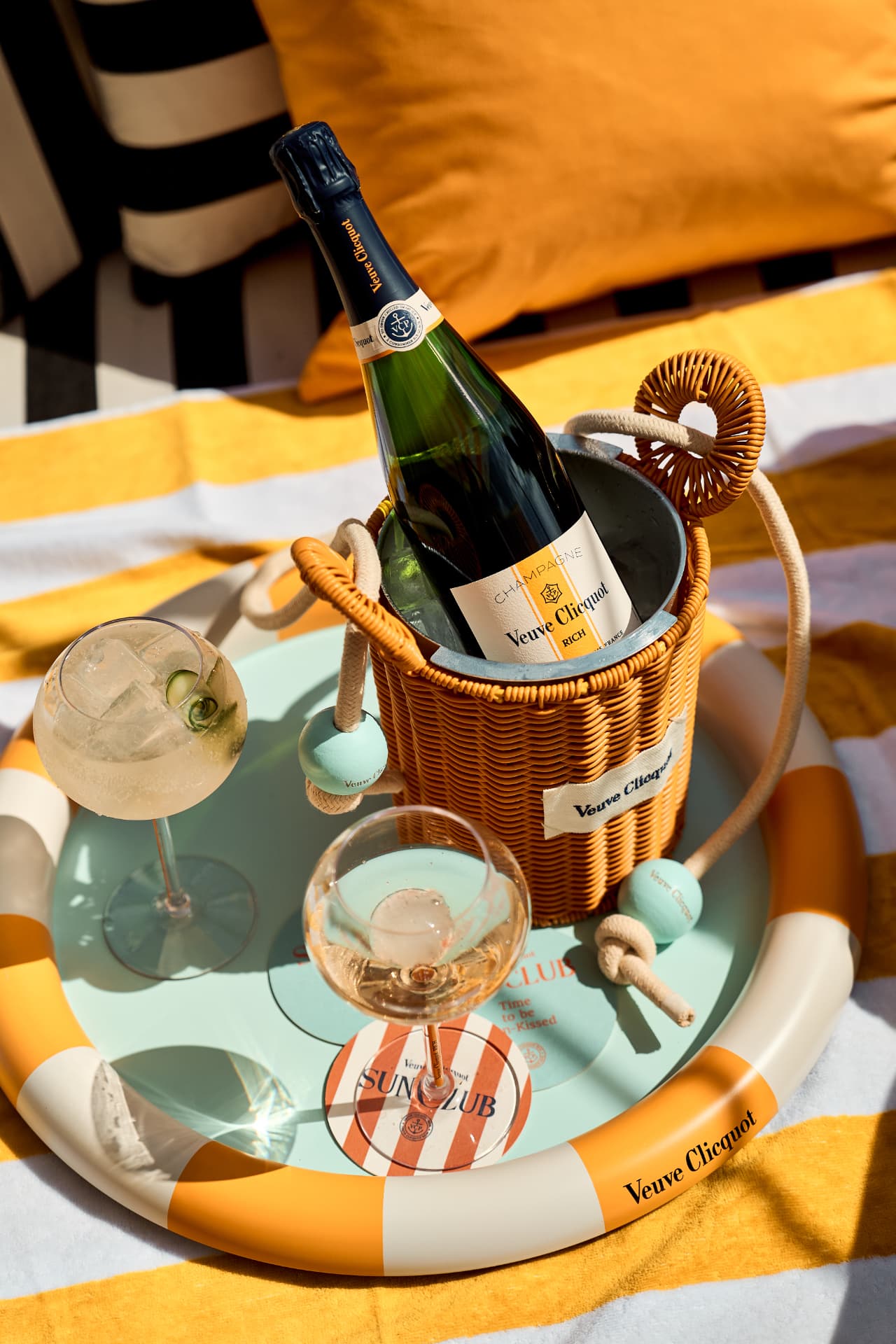 Ice basket and glasses on a striped tray in the sun