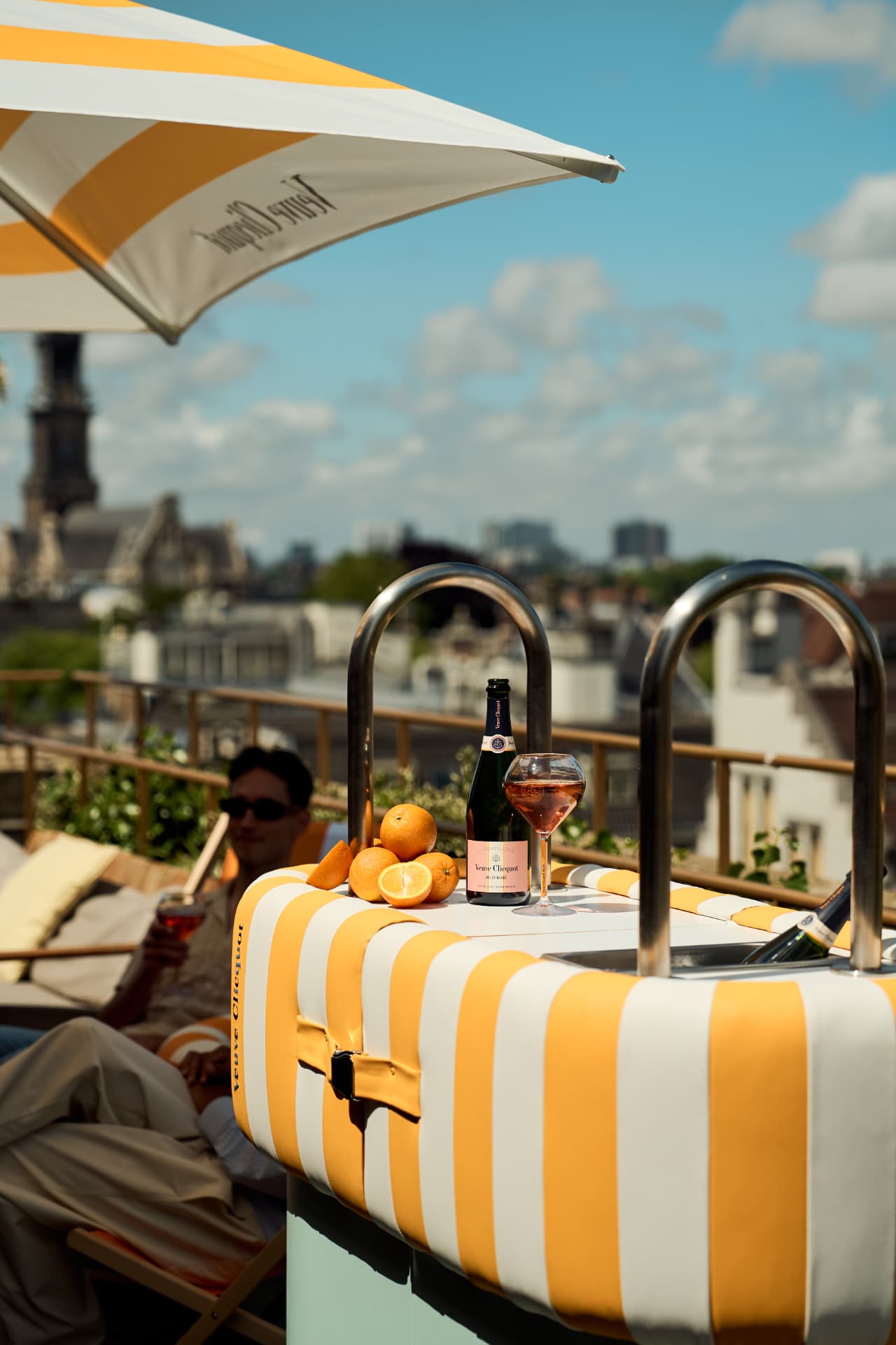 Striped parasol and rose on the terrace above the rooftops