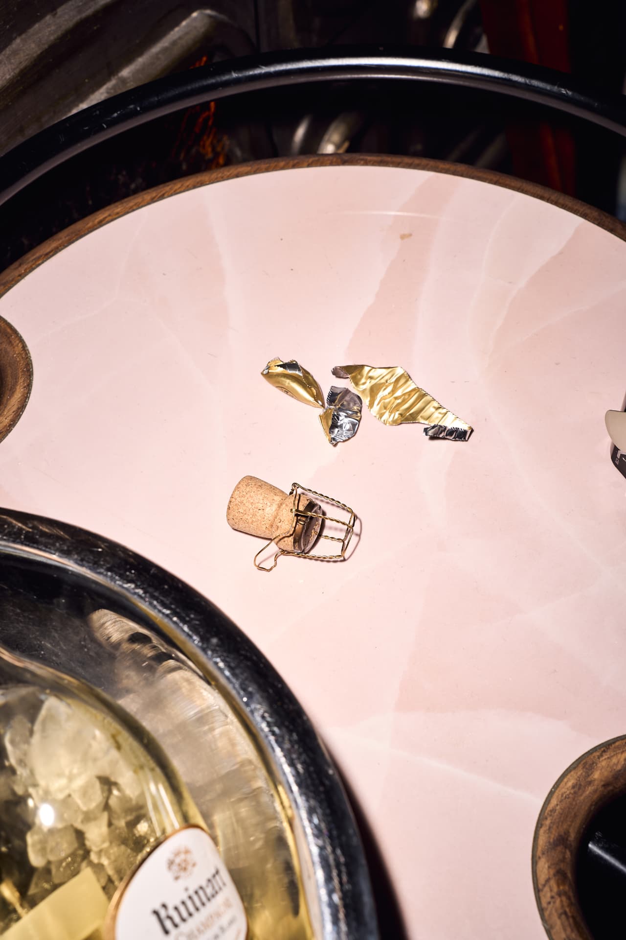 Champagne cork and foil left on a pink marble tray