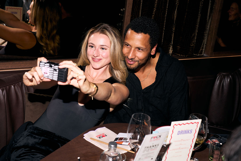Two guests taking a selfie on a compact camera at the premiere dinner