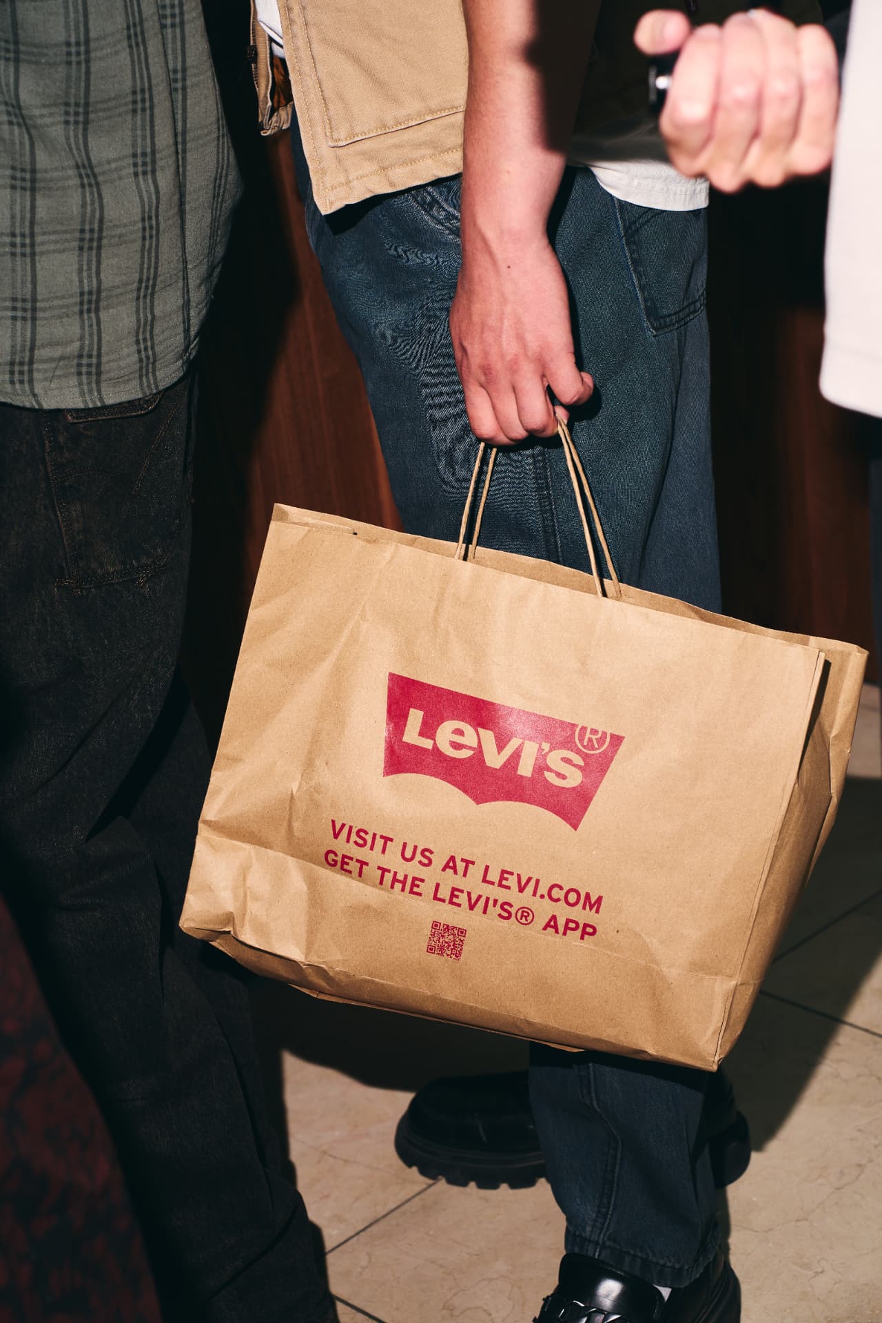 Guest carrying a Levi's paper bag out of the venue
