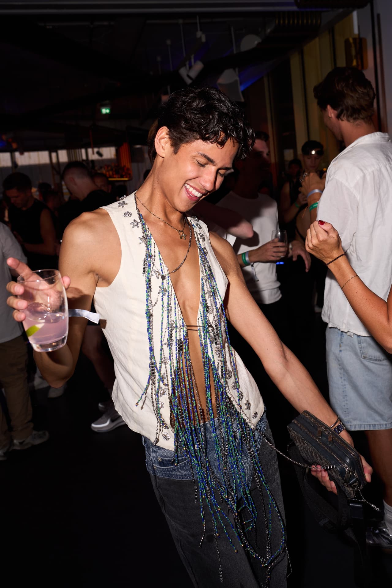 Guest dancing in a beaded waistcoat with a drink in hand