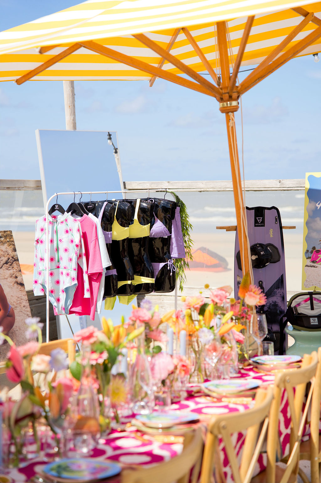 Swimwear rail under a yellow striped parasol
