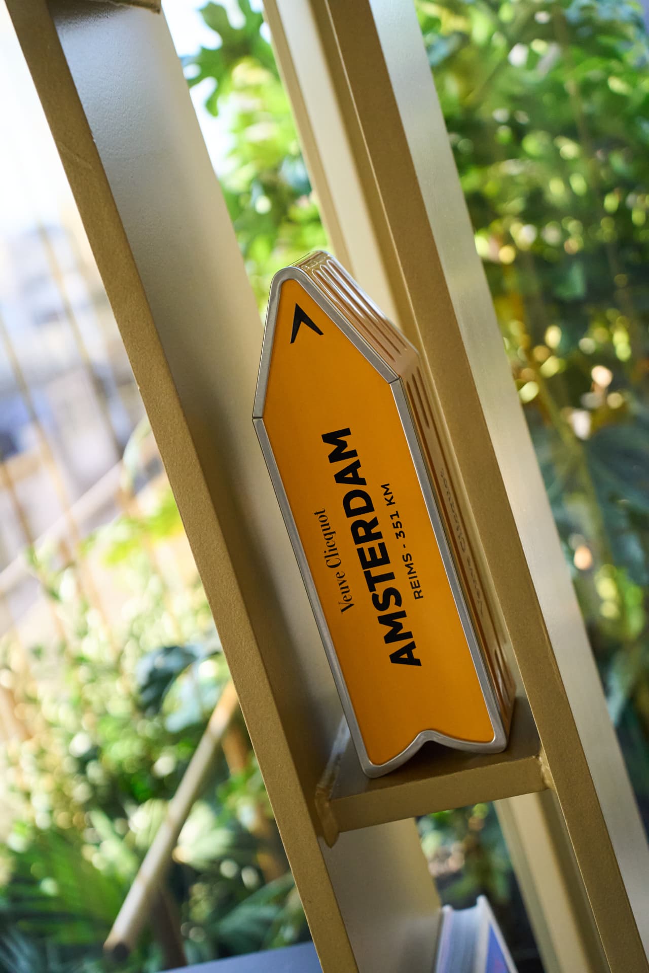 Yellow Amsterdam arrow sign in Veuve Clicquot branding
