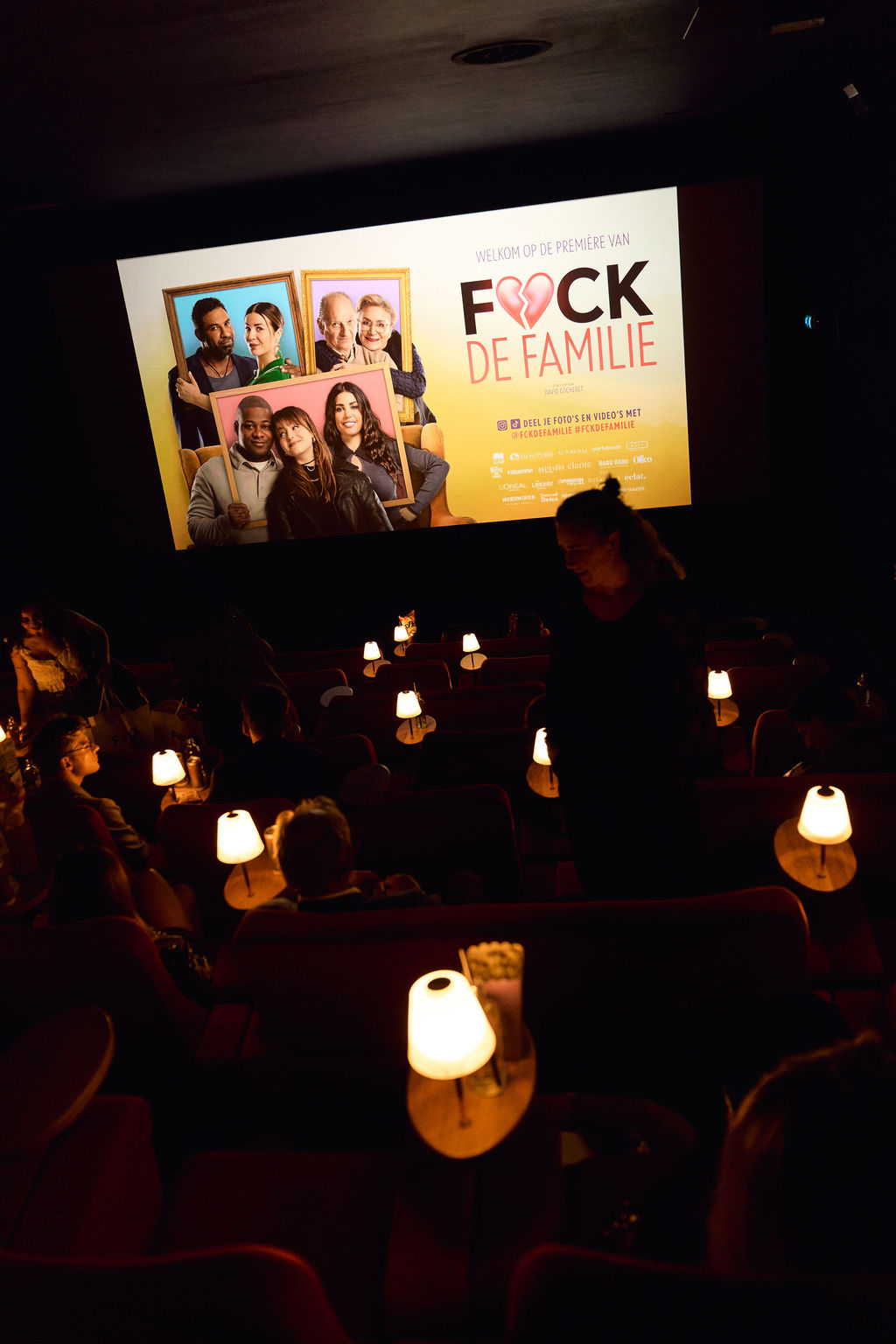 The F*ck de Familie premiere slide on the screen at Pathé City with lamplit seats