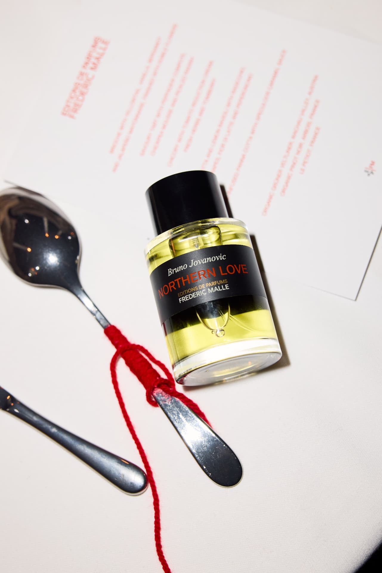 Northern Love bottle on the menu card with red thread and silver cutlery
