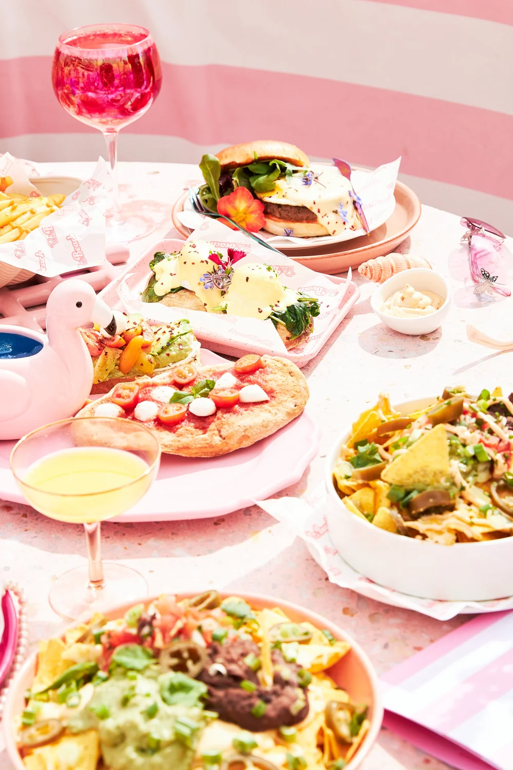Brunch spread with burger, nachos and pink drinks