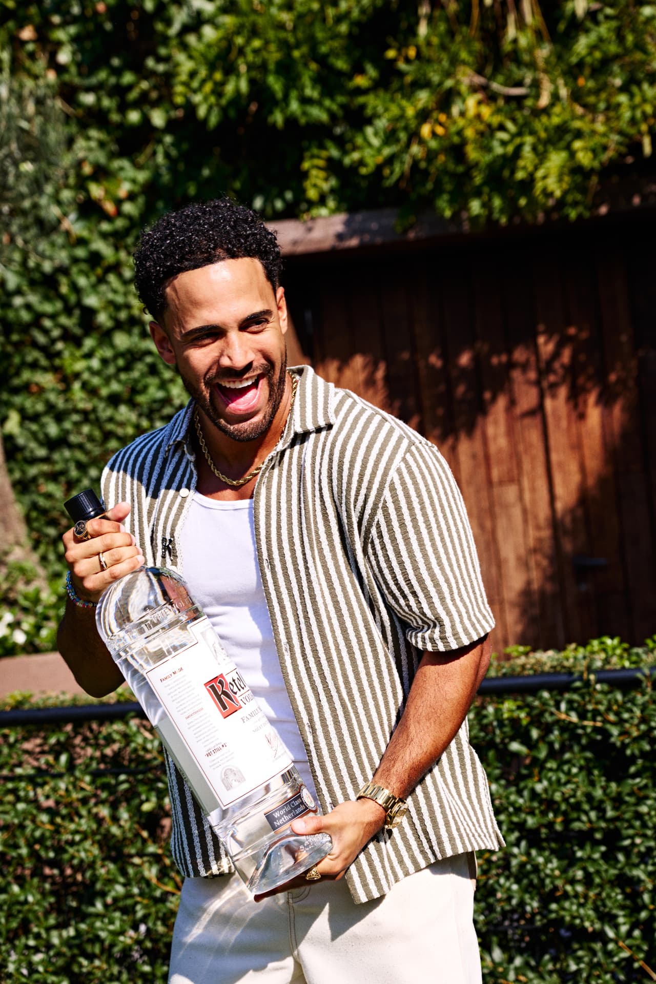Guest holding a Ketel One bottle in the garden