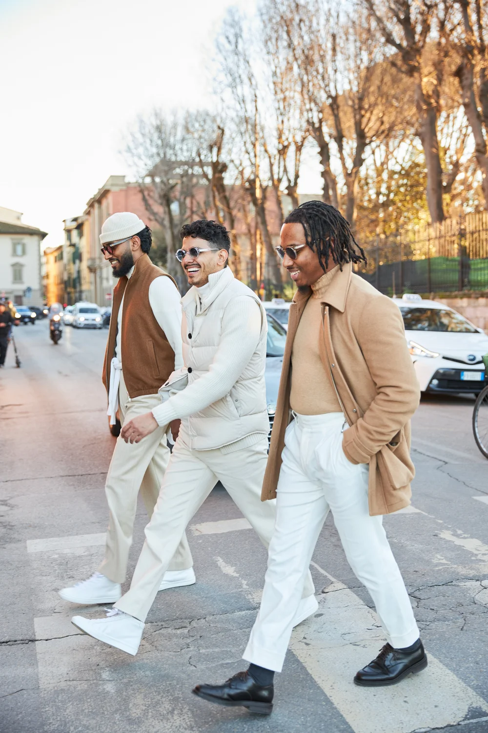 Three men in tailoring crossing a street in Florence