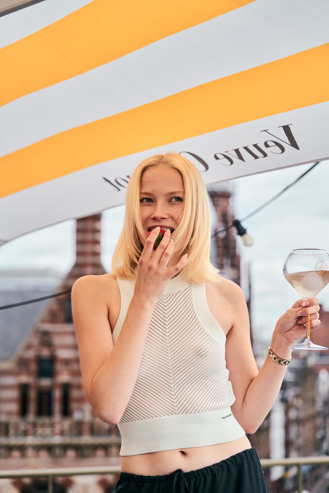 Guest with a strawberry under the striped parasol