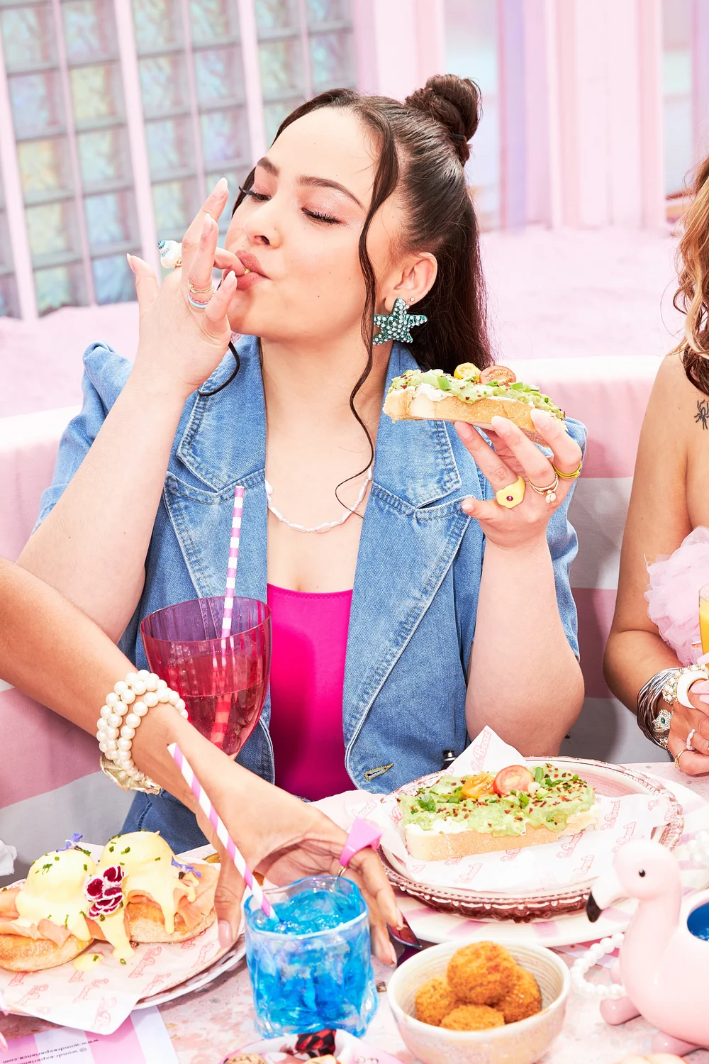 Woman in denim tasting an open sandwich
