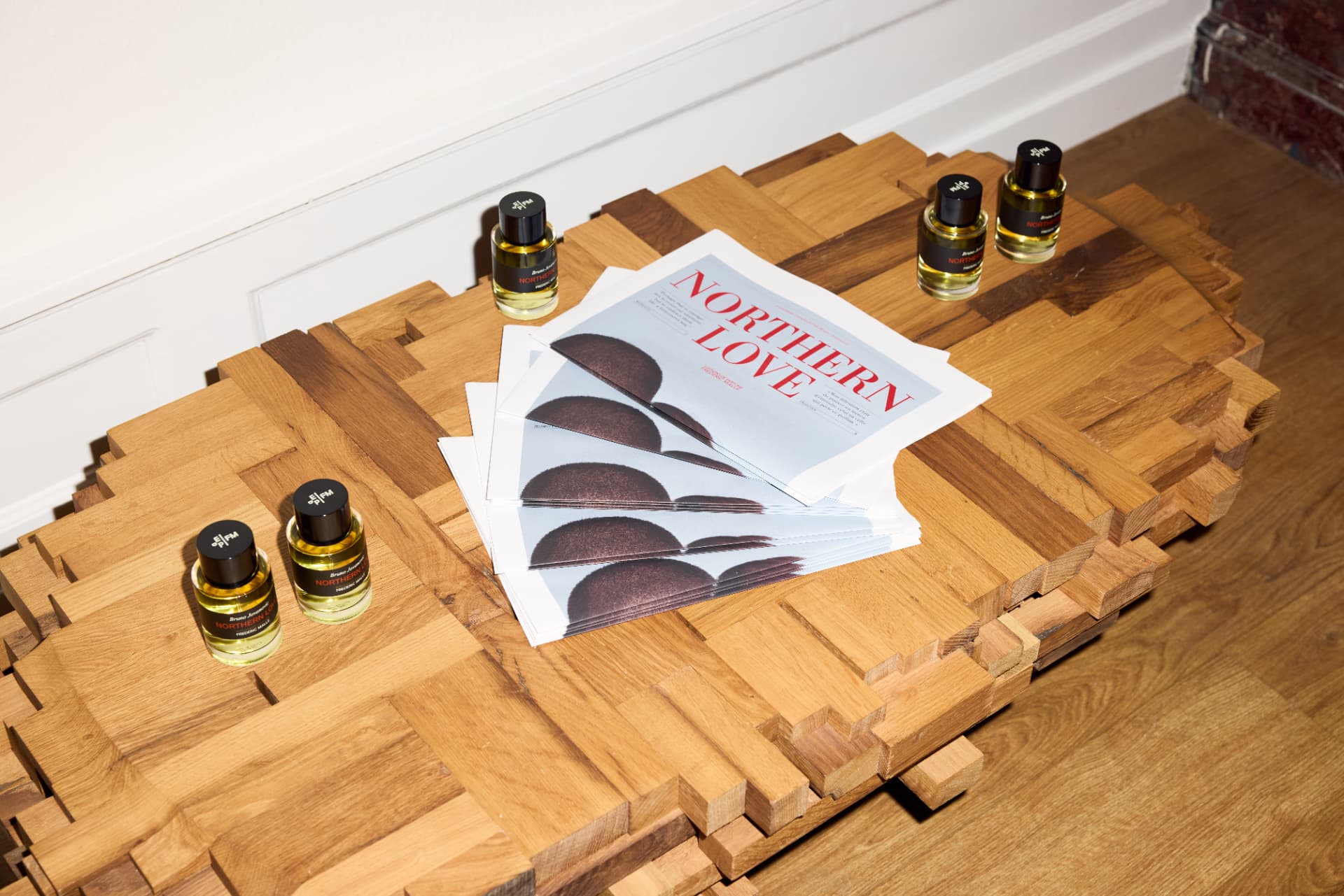 Northern Love bottles and newspapers on a sculpted wooden plinth
