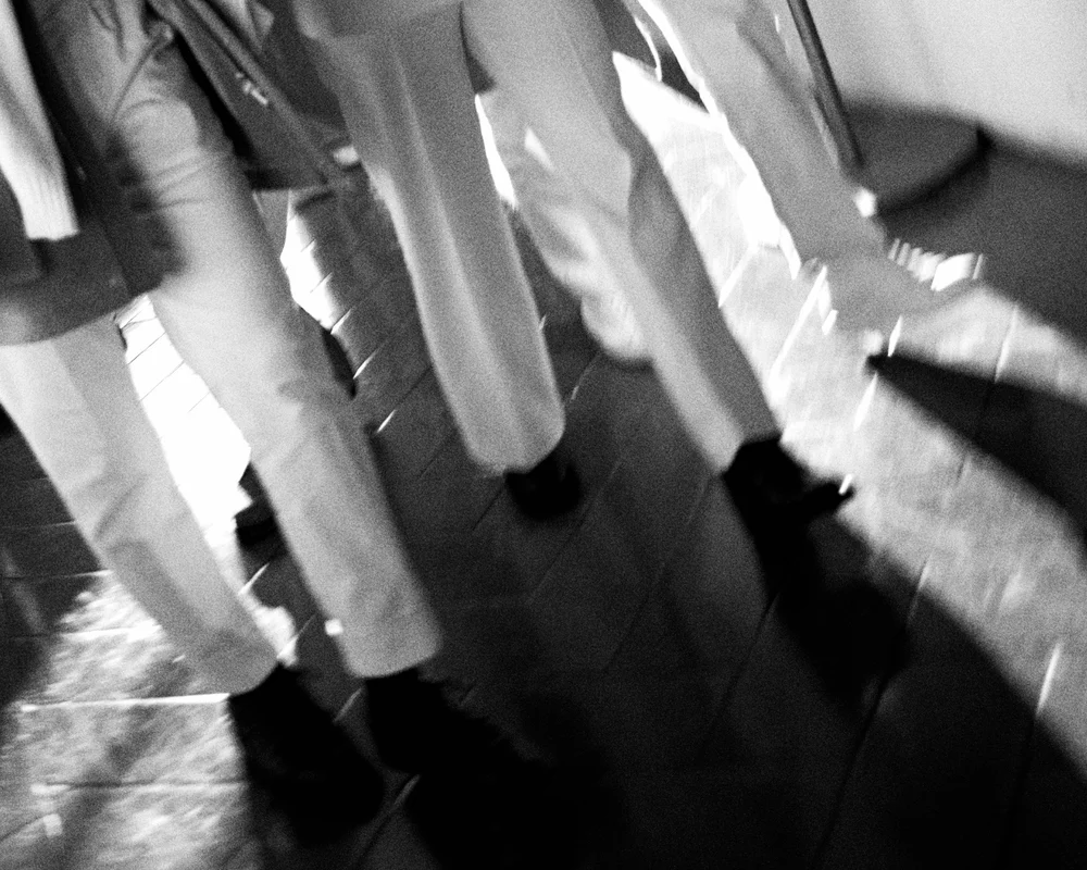 Blurred black and white frame of legs and shoes on tiled floor