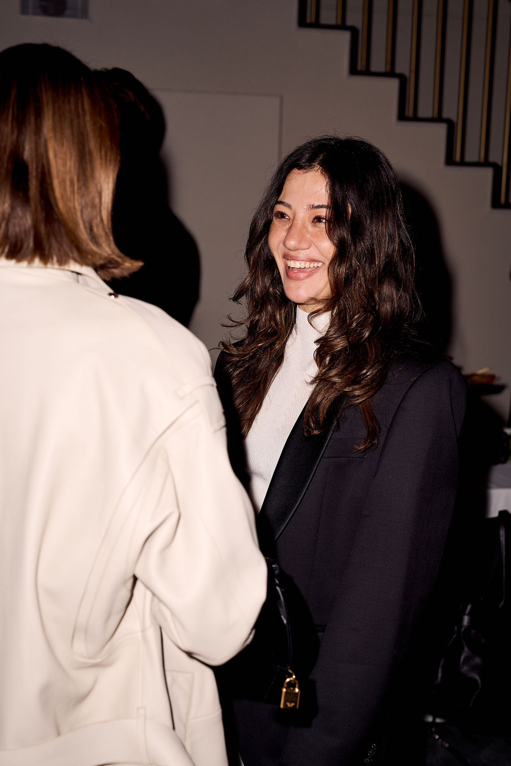 Guest in a black blazer mid conversation