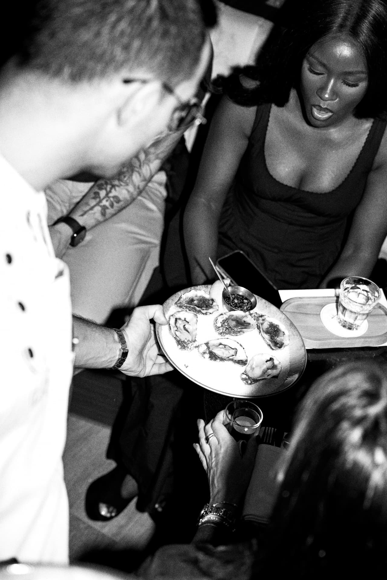 Black and white moment of guests sharing a plate