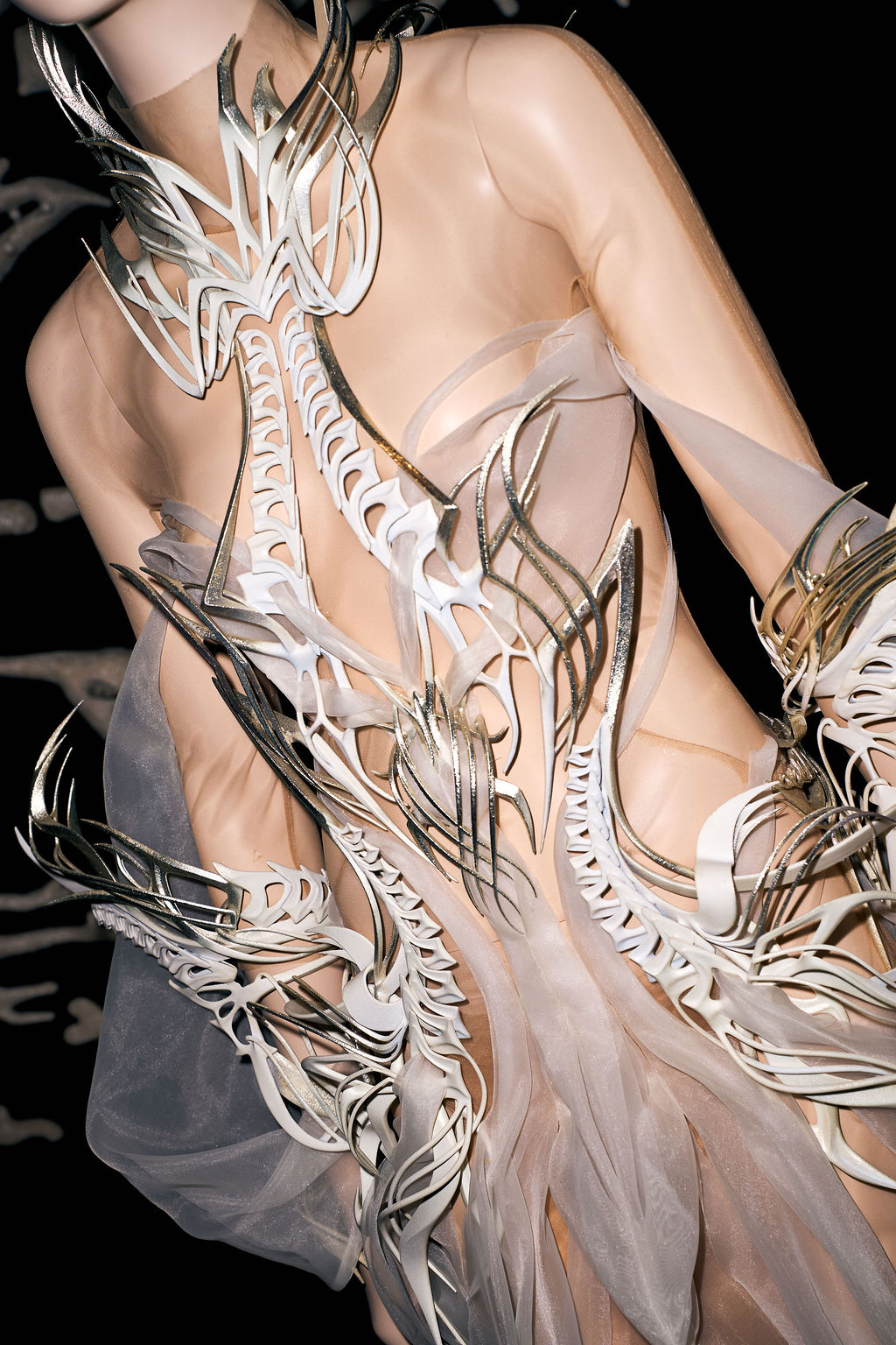 Gold and white forms curling across sheer organza