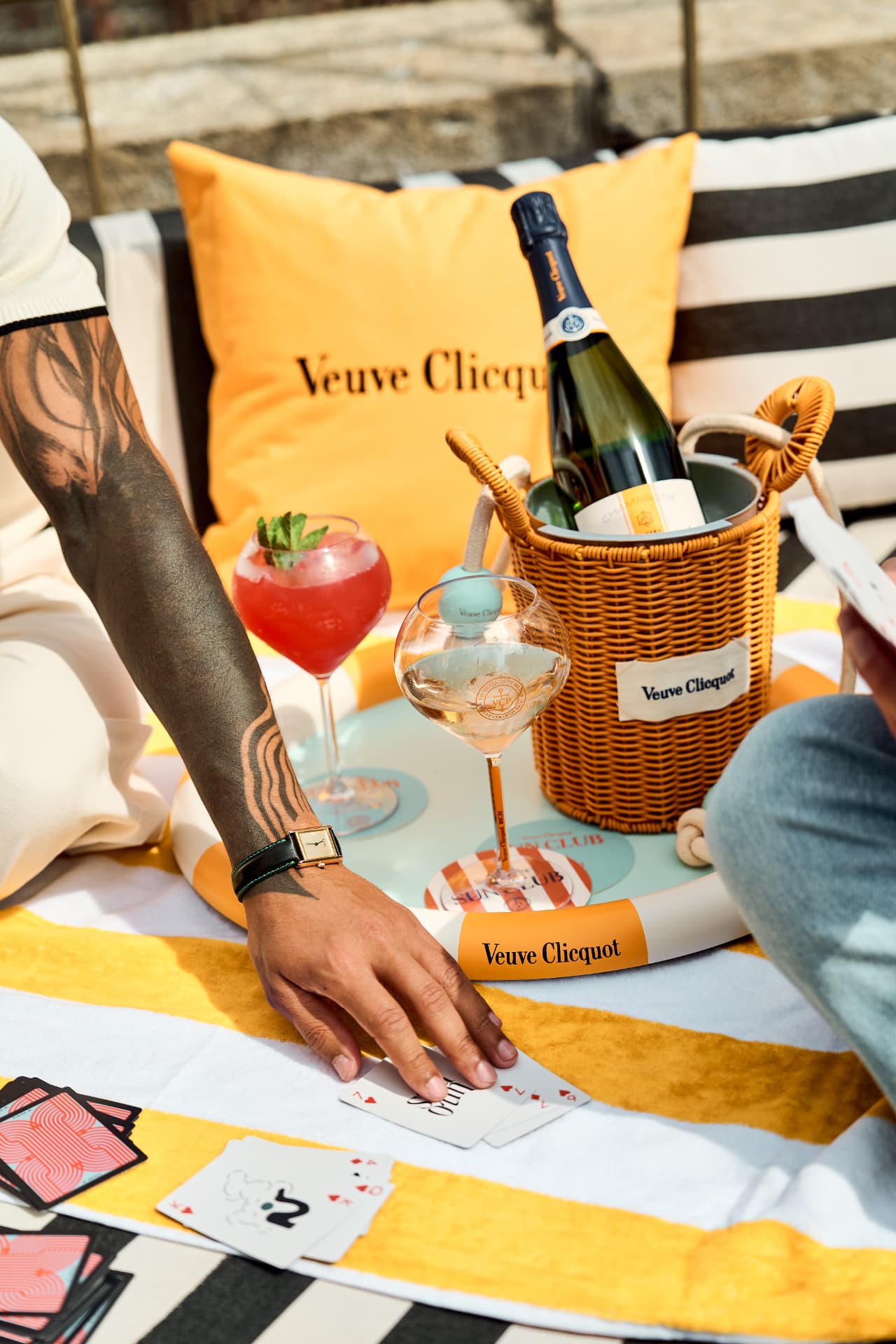 Cards, cocktails and an ice basket on a beach towel