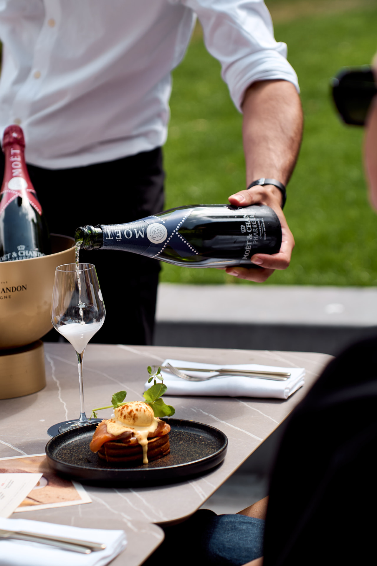 Champagne poured beside eggs benedict