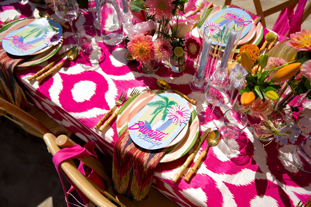 Table setting in pink ikat with painted plates and flowers