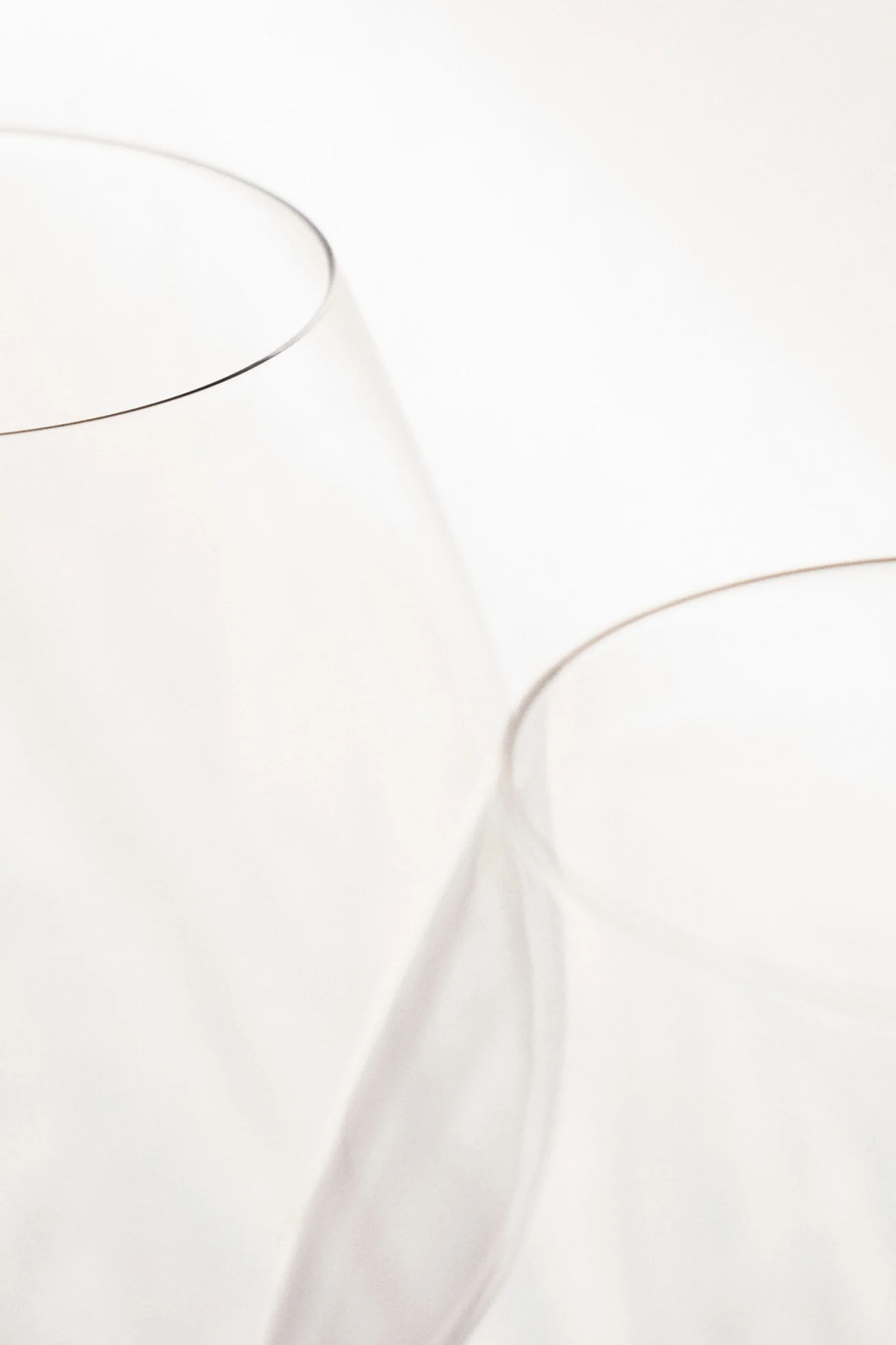 Two overlapping crystal glasses in soft white light