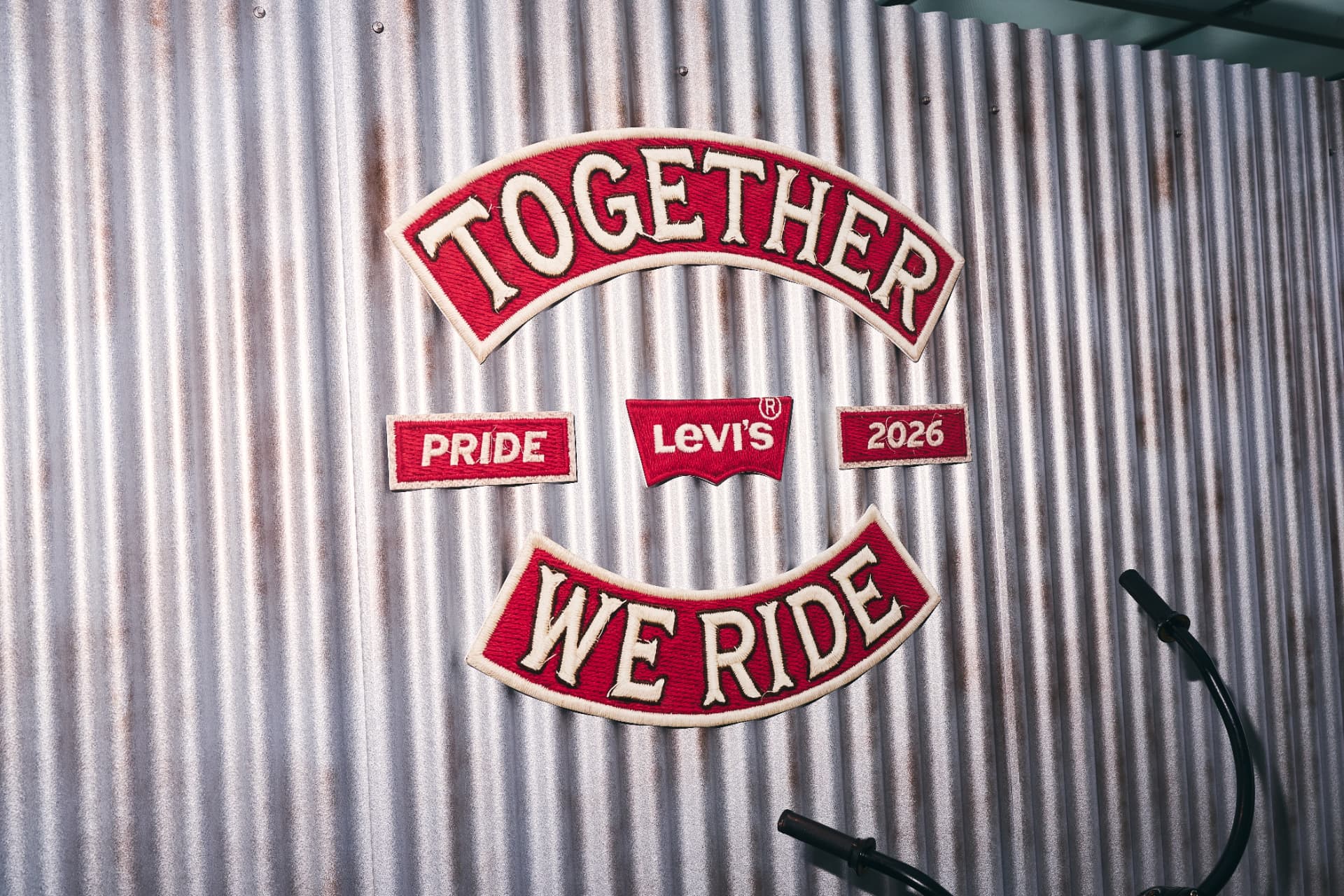 Together We Ride Levi's Pride 2026 patch set on a corrugated metal wall