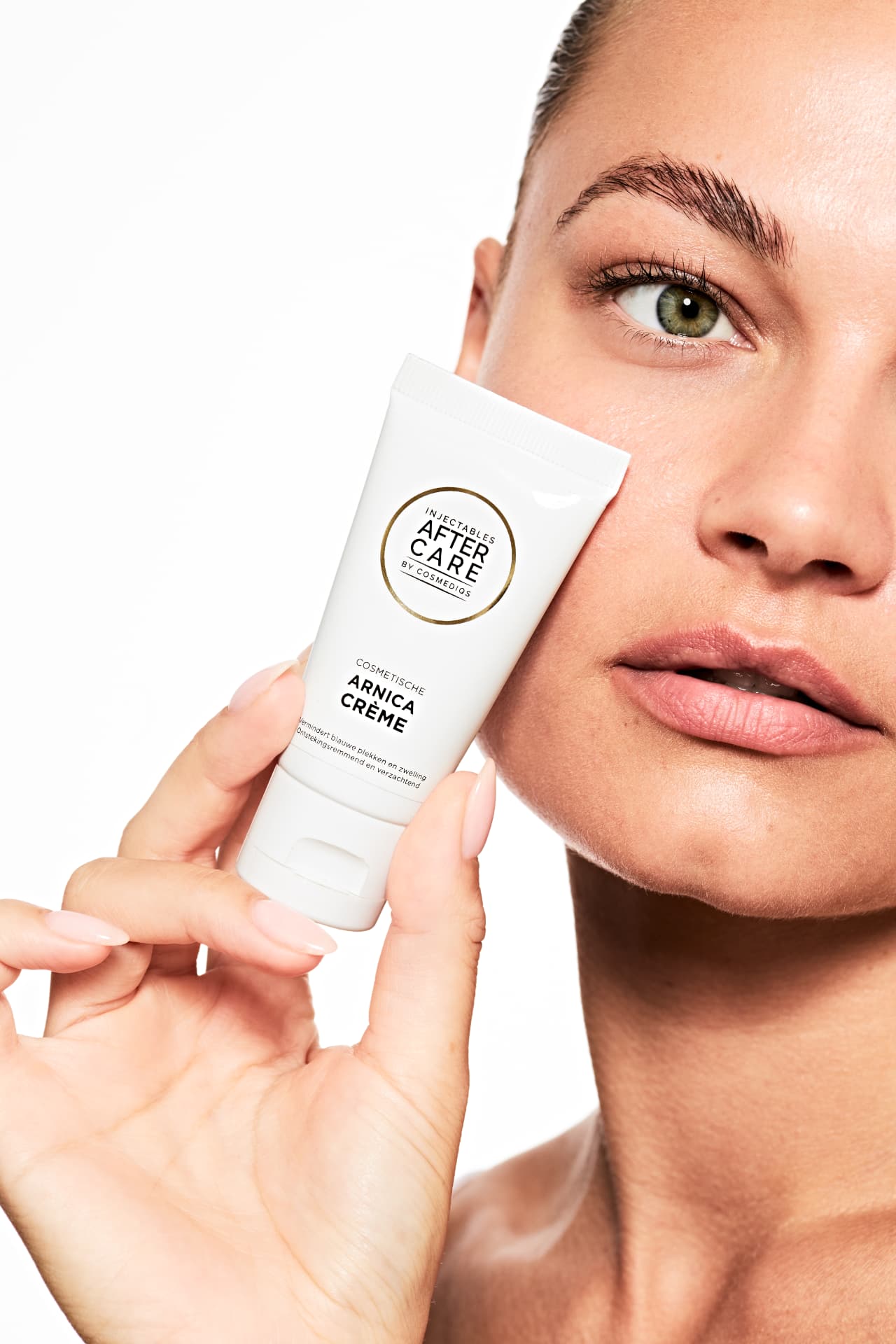 Model holding the Injectables Aftercare arnica cream to her cheek