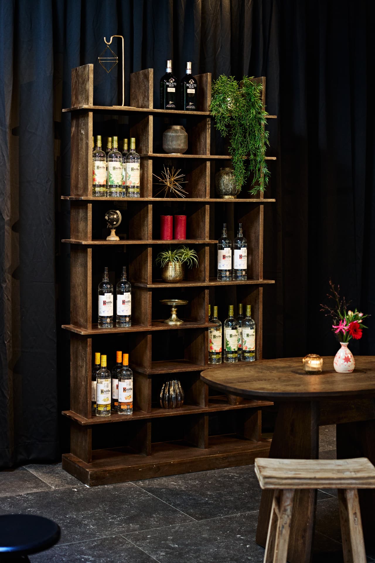 Bottle display and plants in a softly lit interior