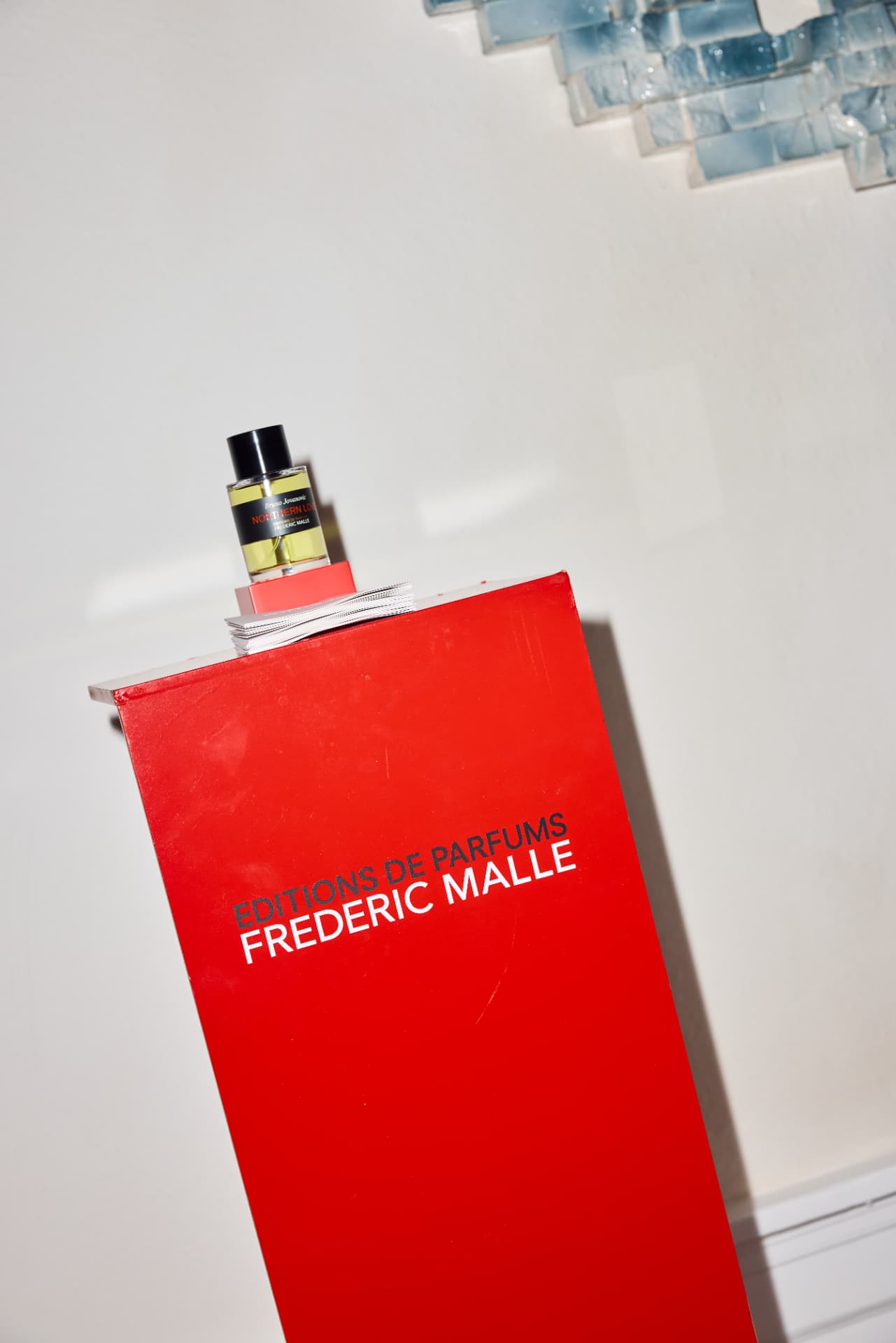 Frederic Malle bottle on a red display column in the gallery